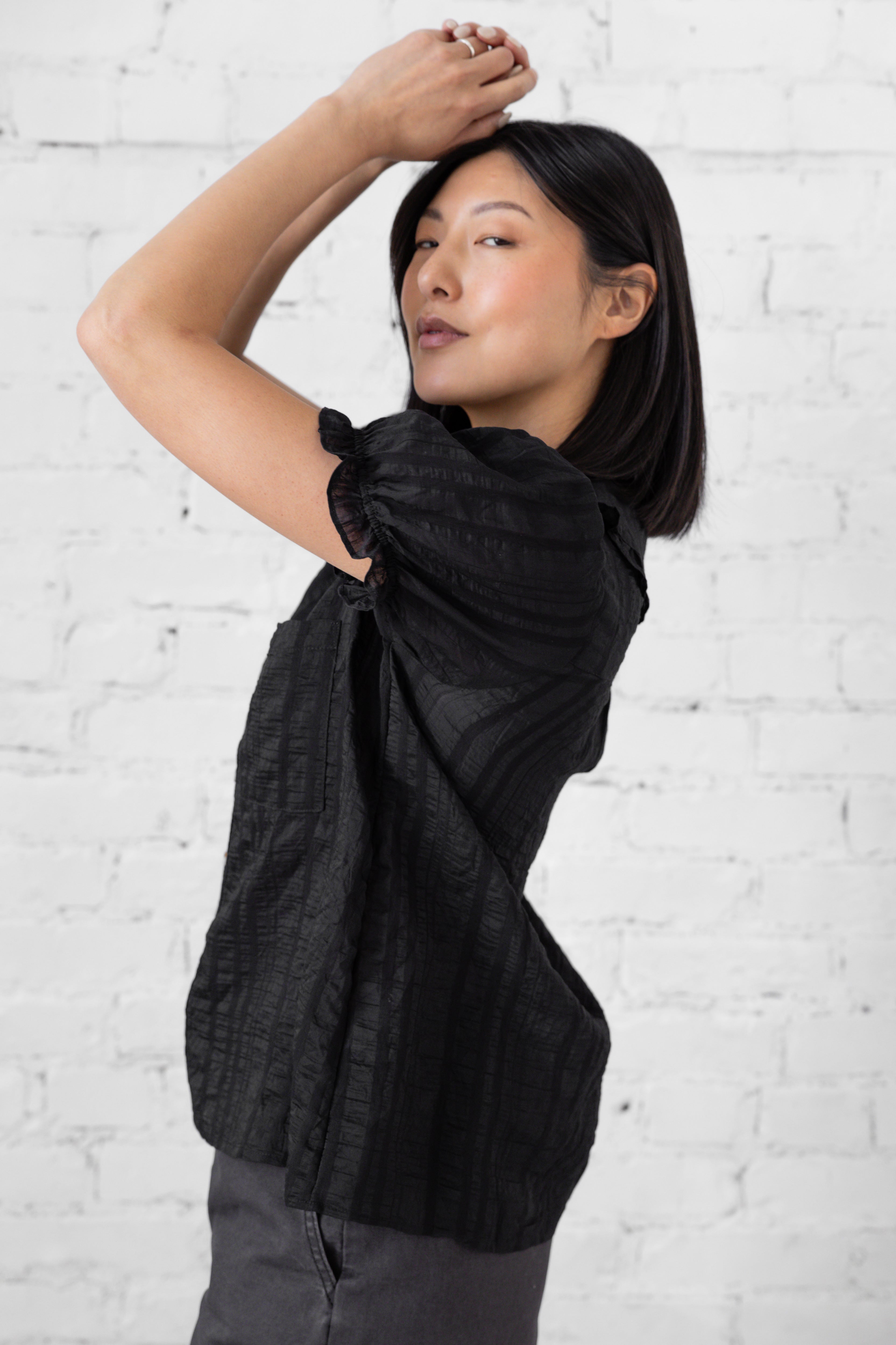 Model is wearing full length blouse with peter pan collar and button up.