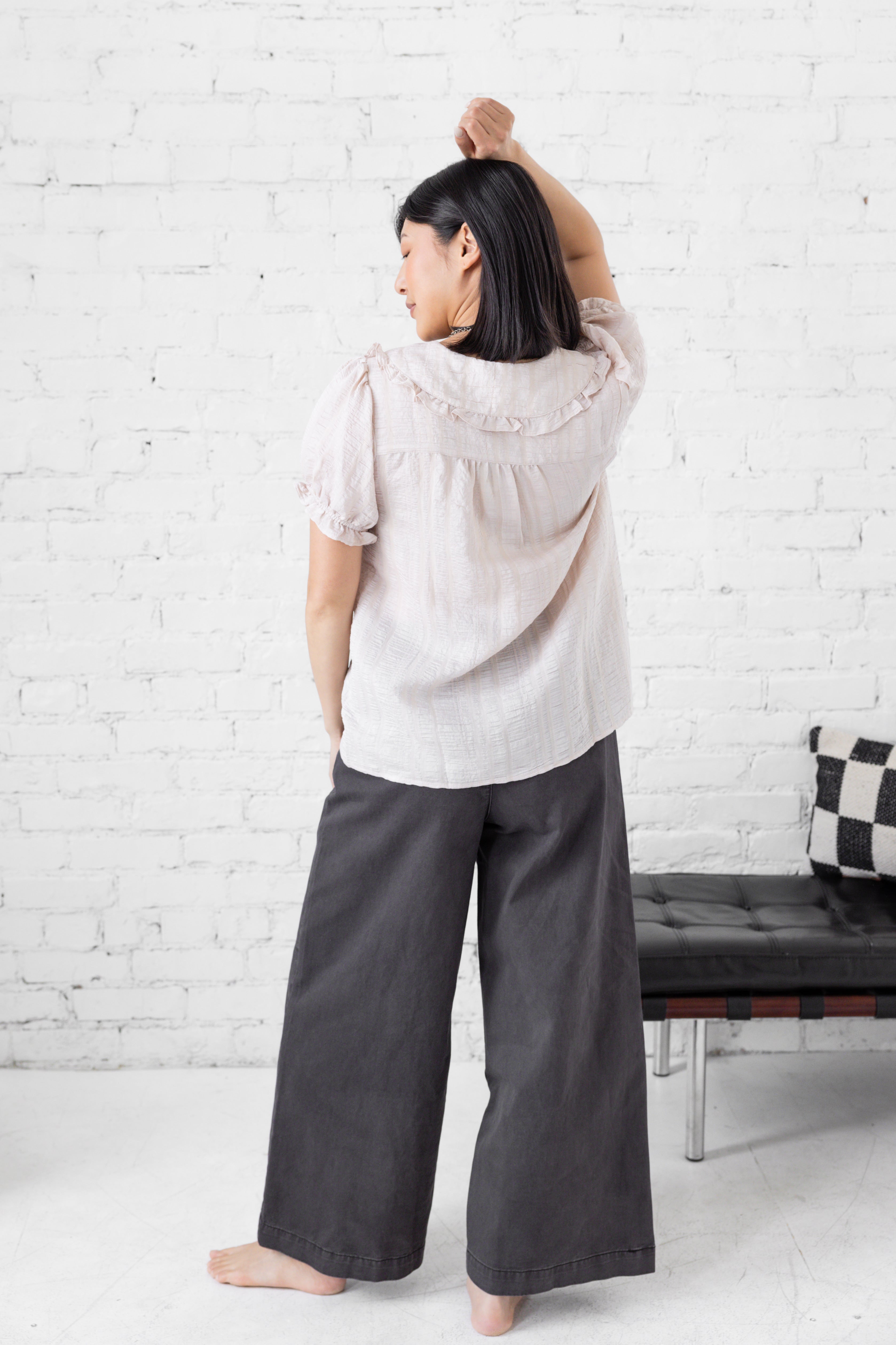 Model is wearing wide leg high rise trousers.