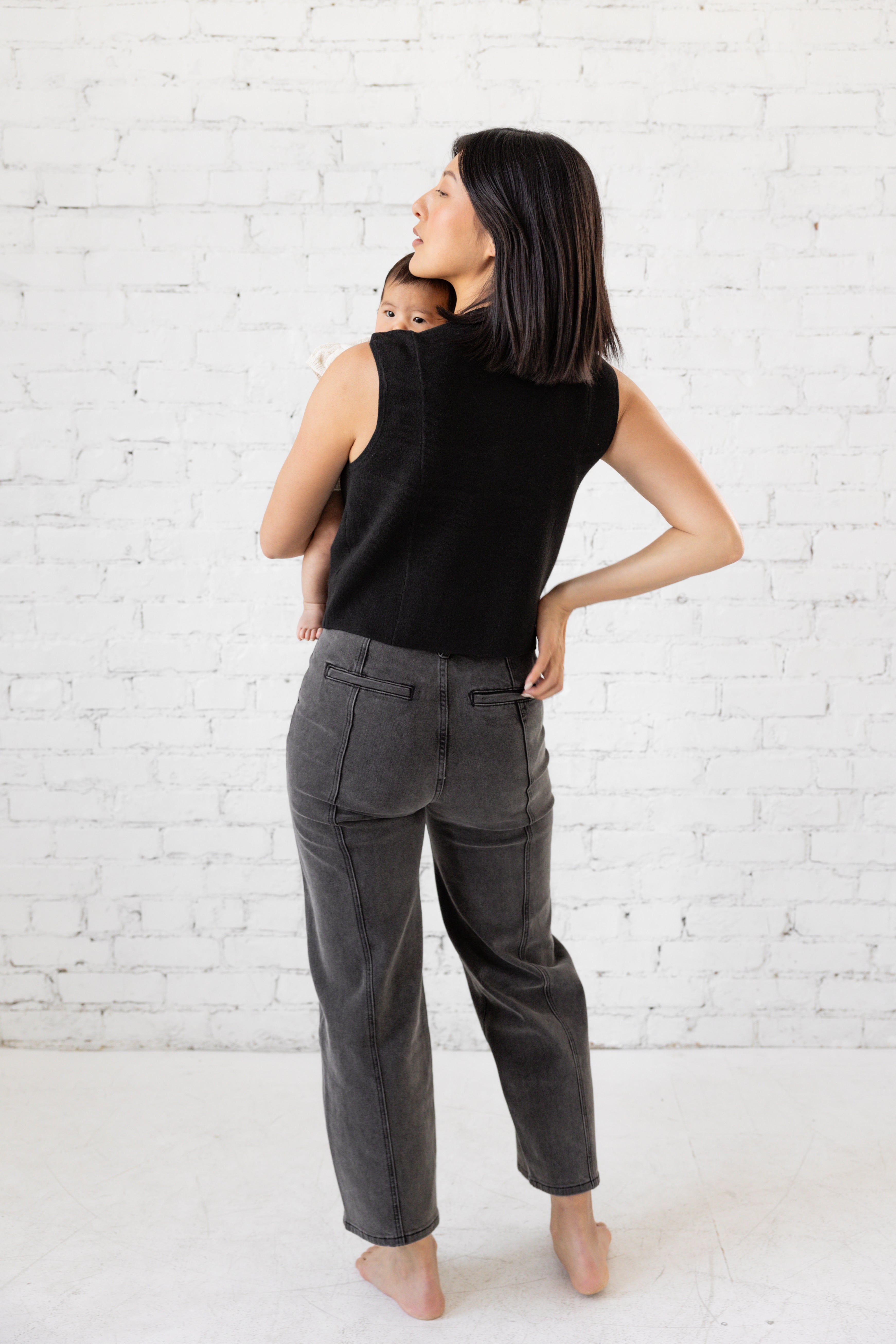 Model is wearing high waist black jeans with deep cargo pockets.