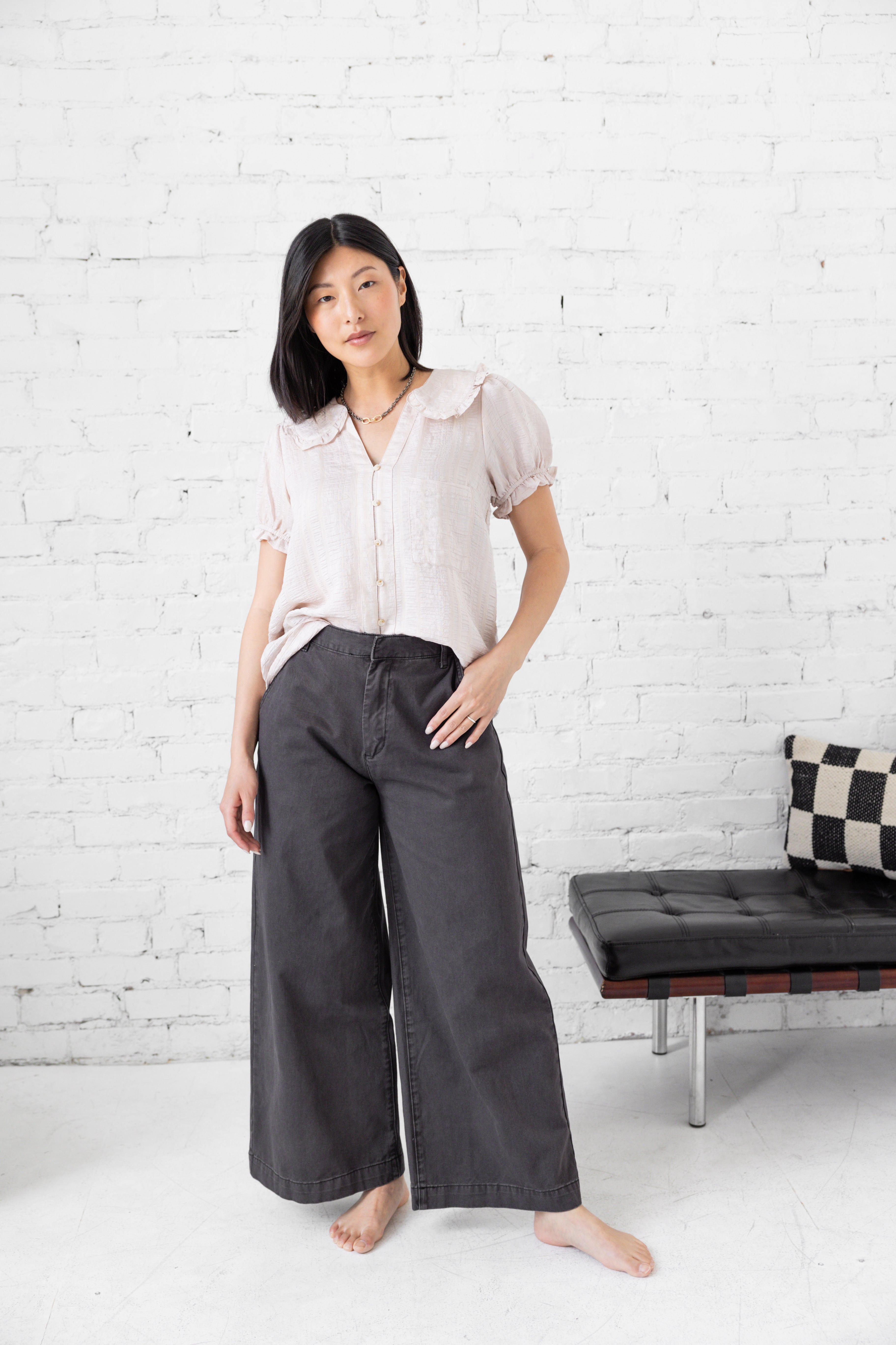 Model is wearing wide leg high rise trousers.