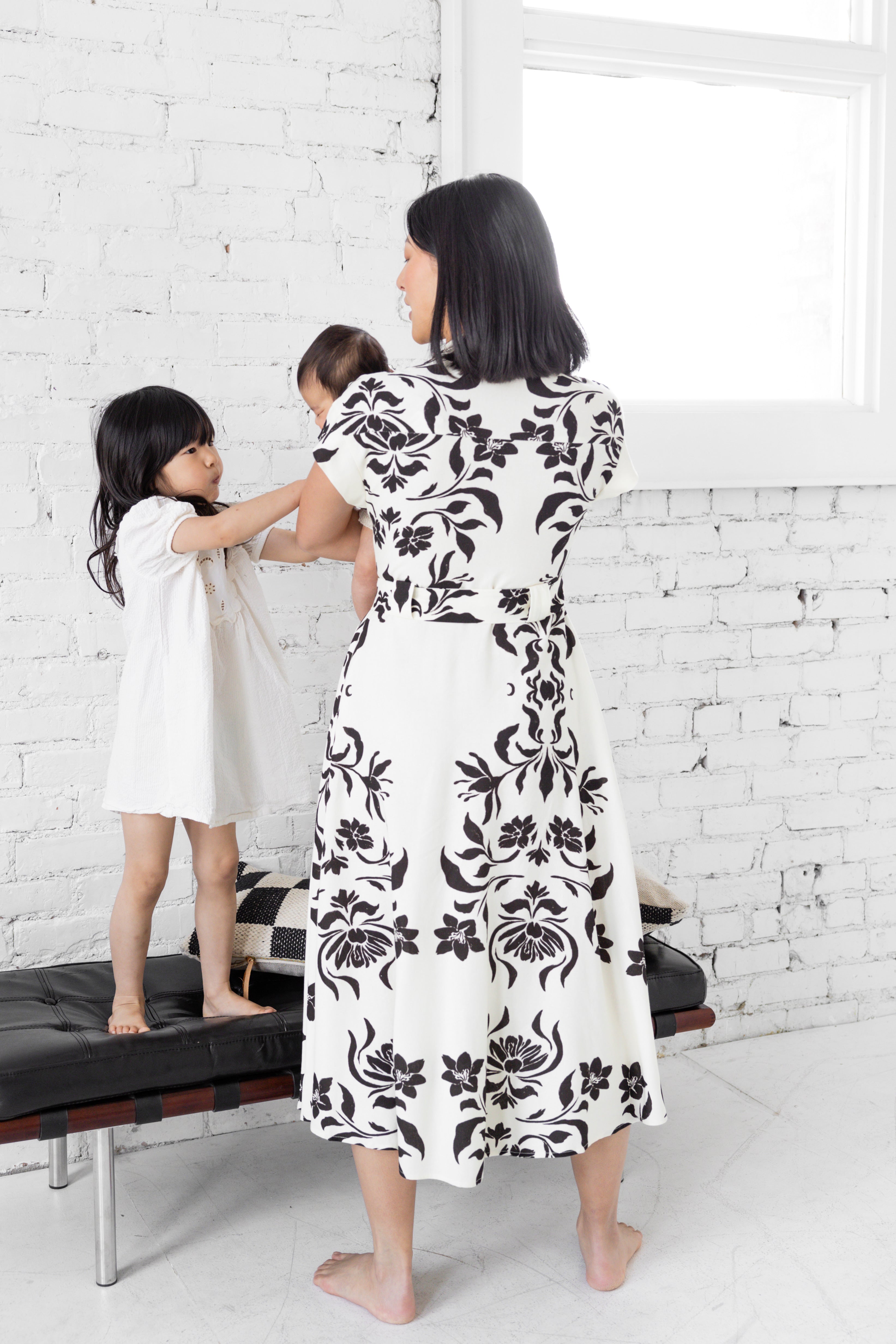 Model is wearing midi collared dress with belt with her family.