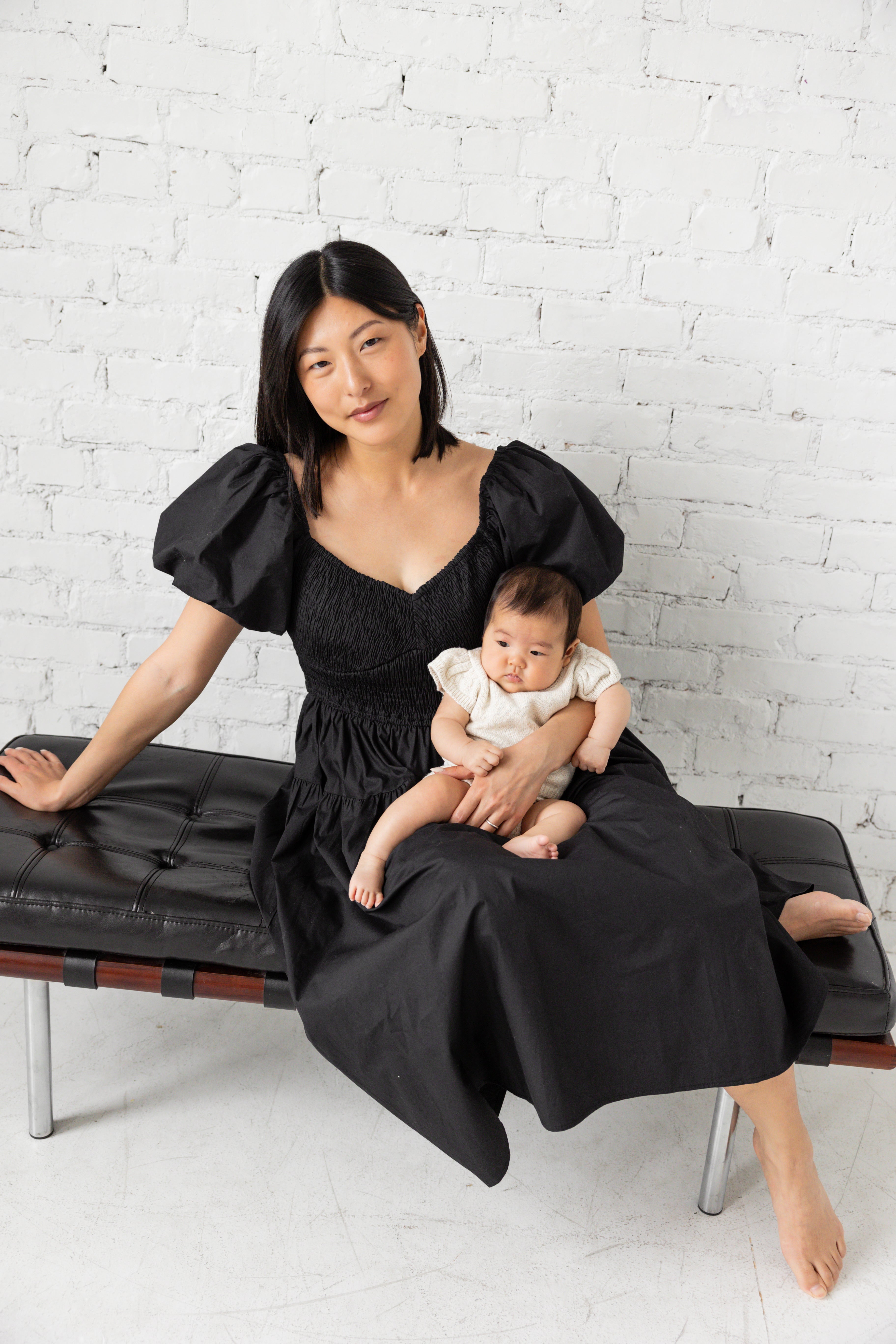 Photo shoot of model in black midi dress with her children.