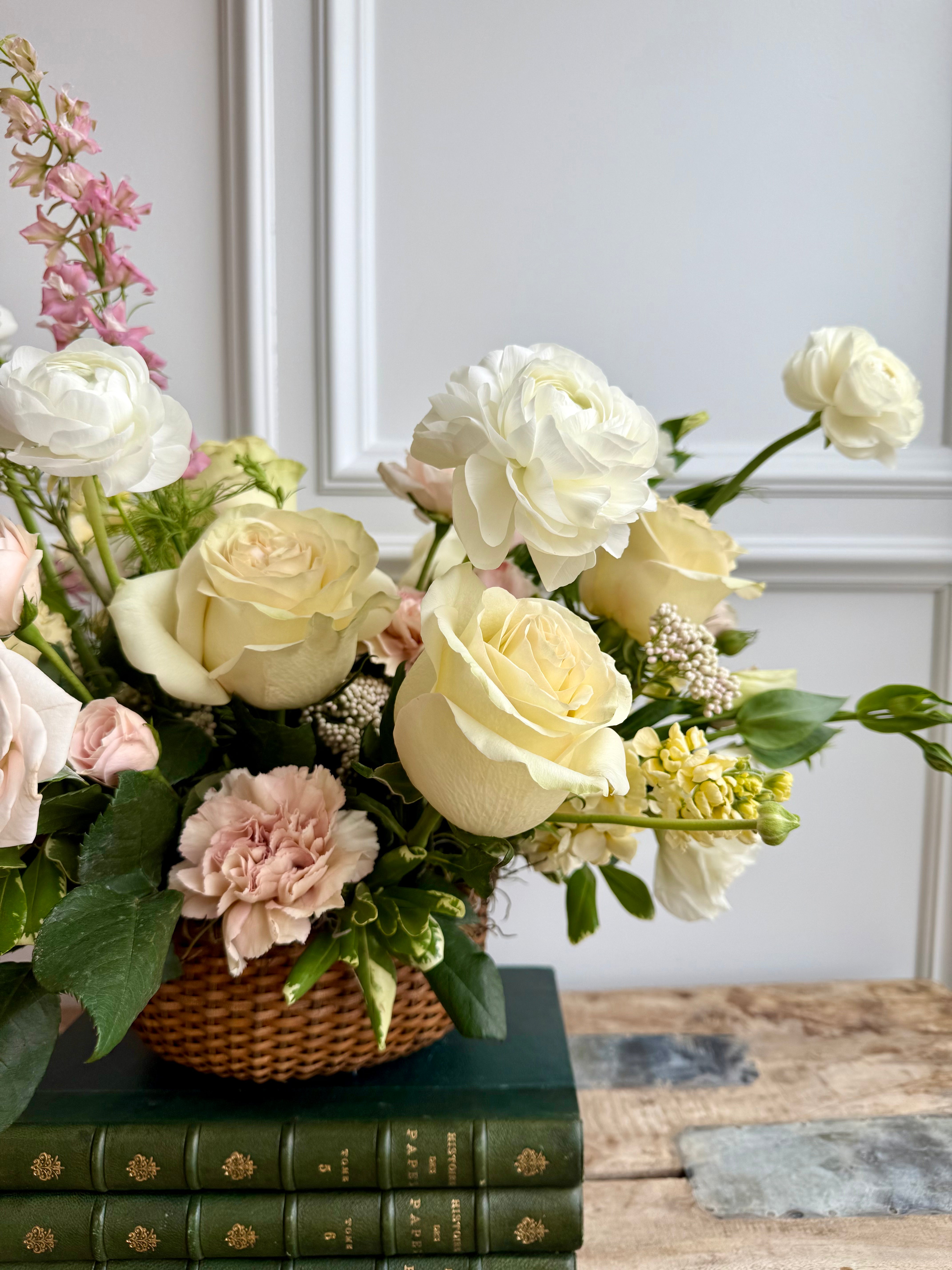 A soft and elegant floral arrangement in a woven basket