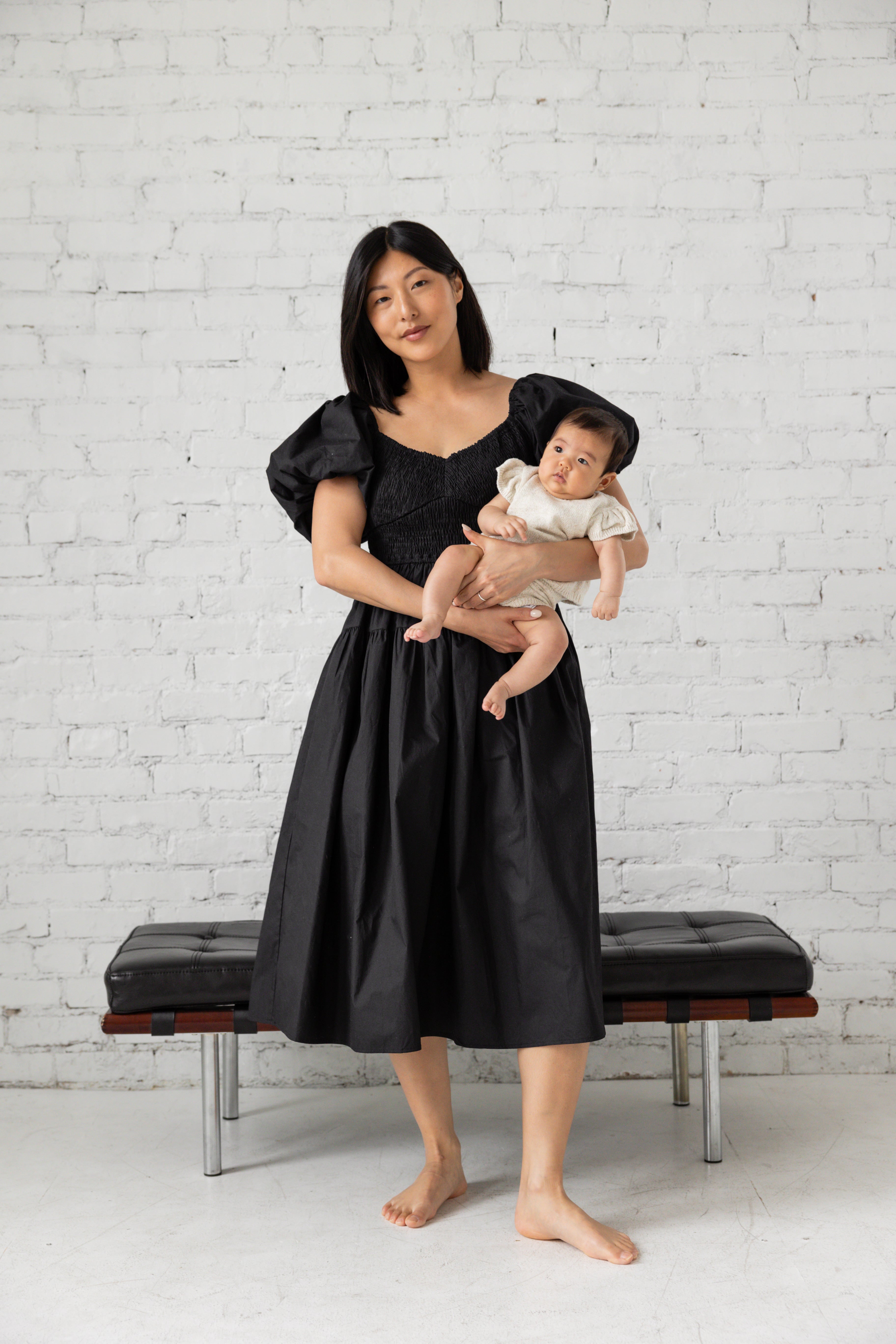 Photo shoot of model in black midi dress with her children.