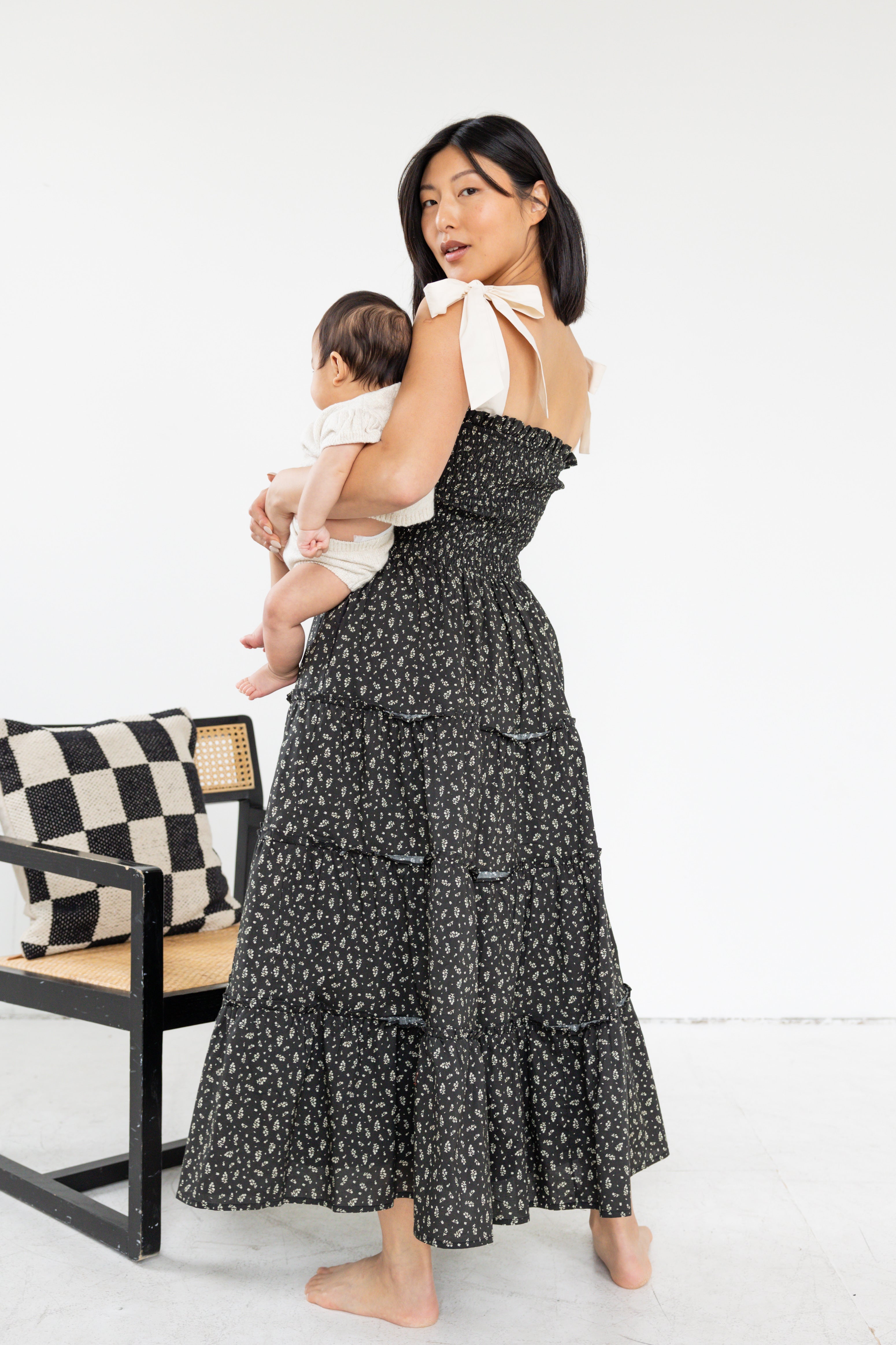 Model is wearing midi floral dress with tank tied bows.