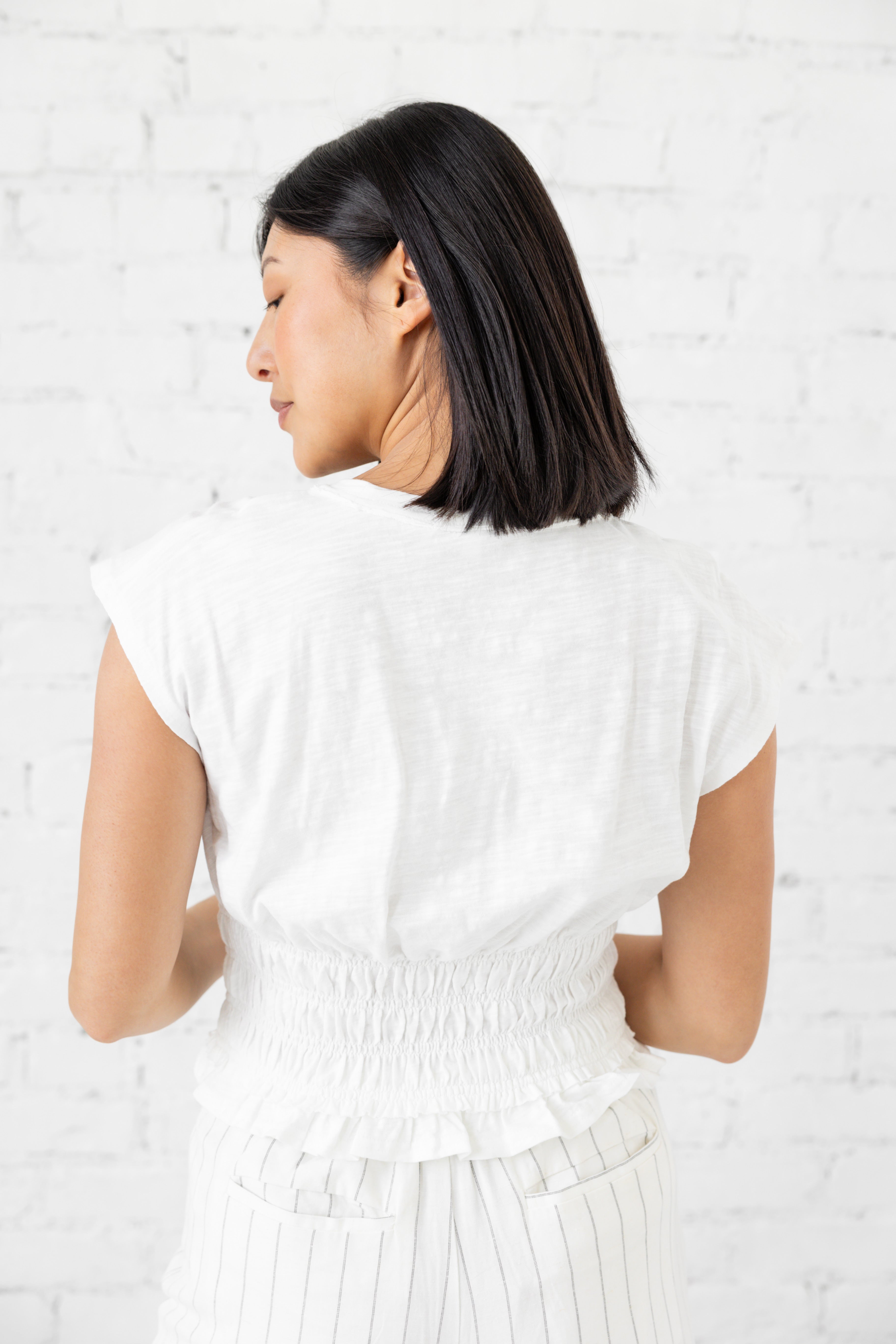 Model is wearing black full length fitted short-sleeve blouse.