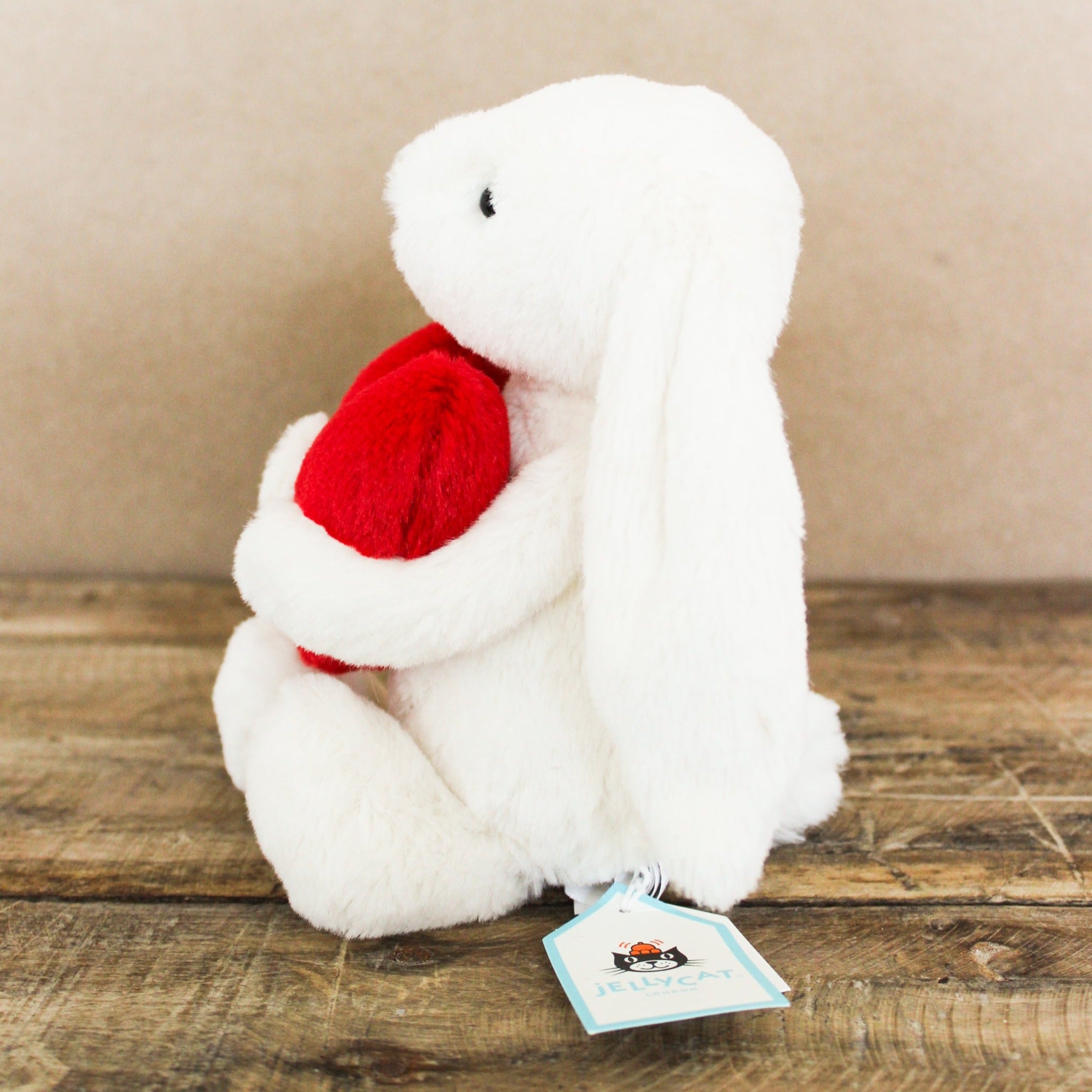 Stuffed bunny with floppy ears and holding a red heart