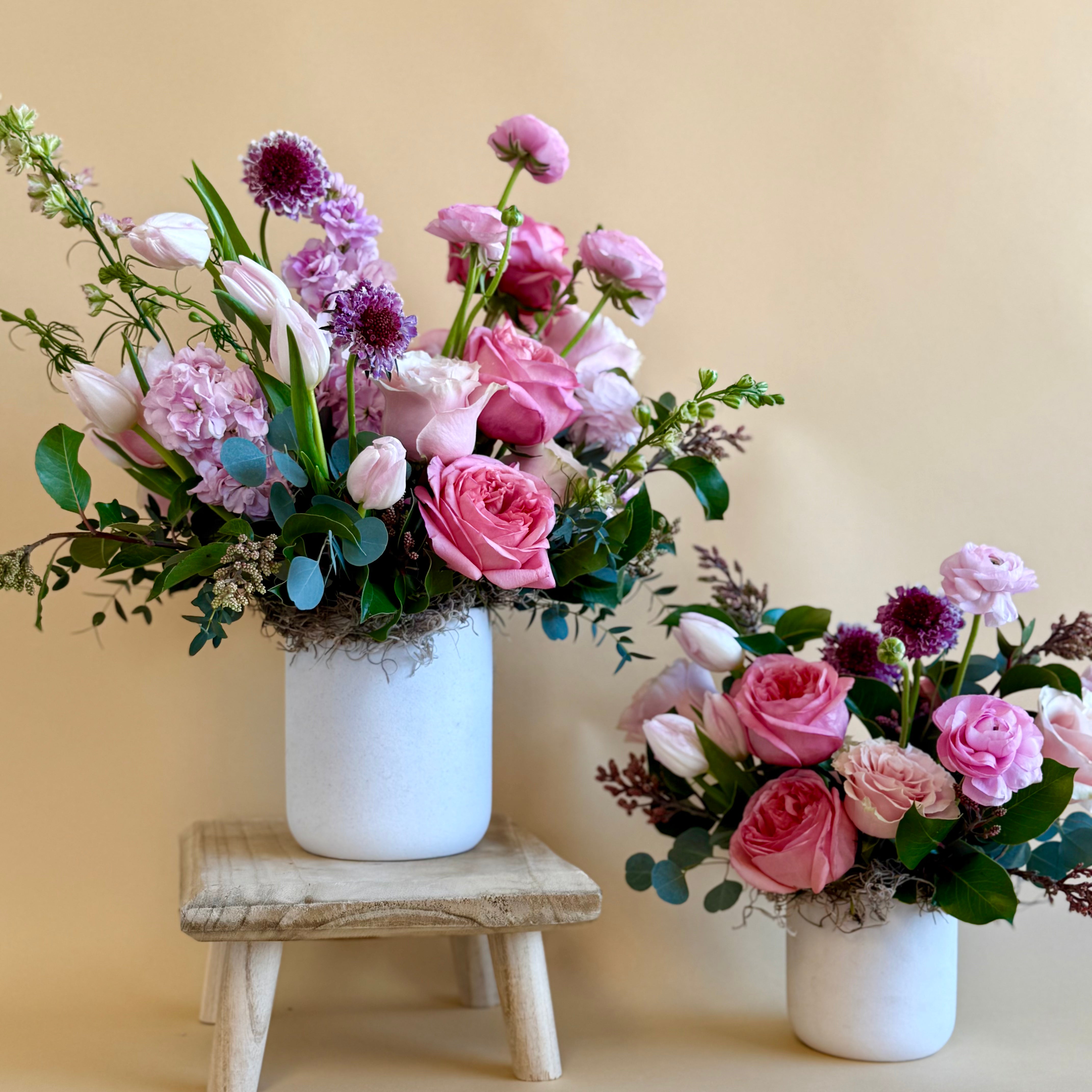 Purple and pink floral bouquet vase arrangement in two different sizes