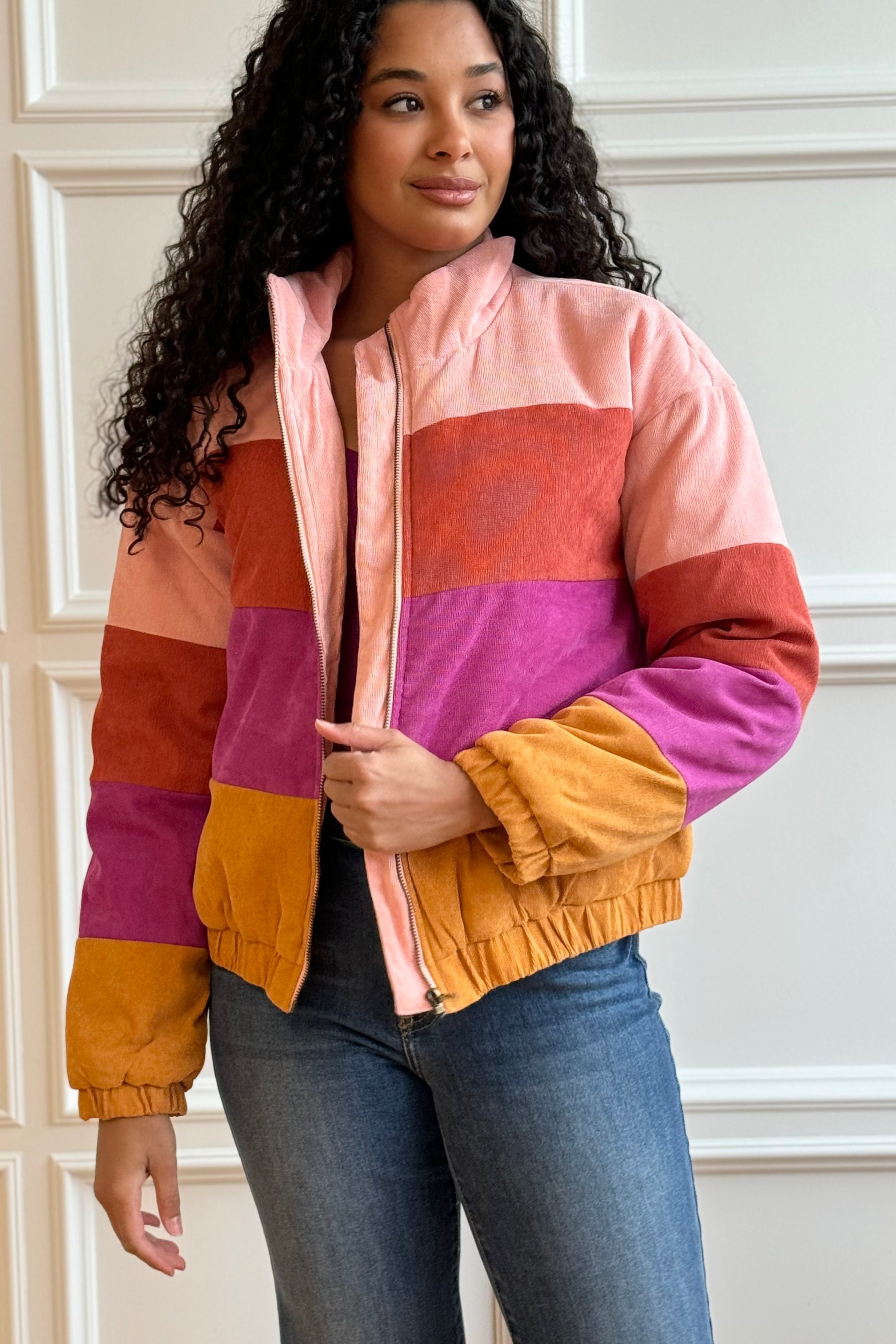 Woman looking away holding her multi-colored coat.