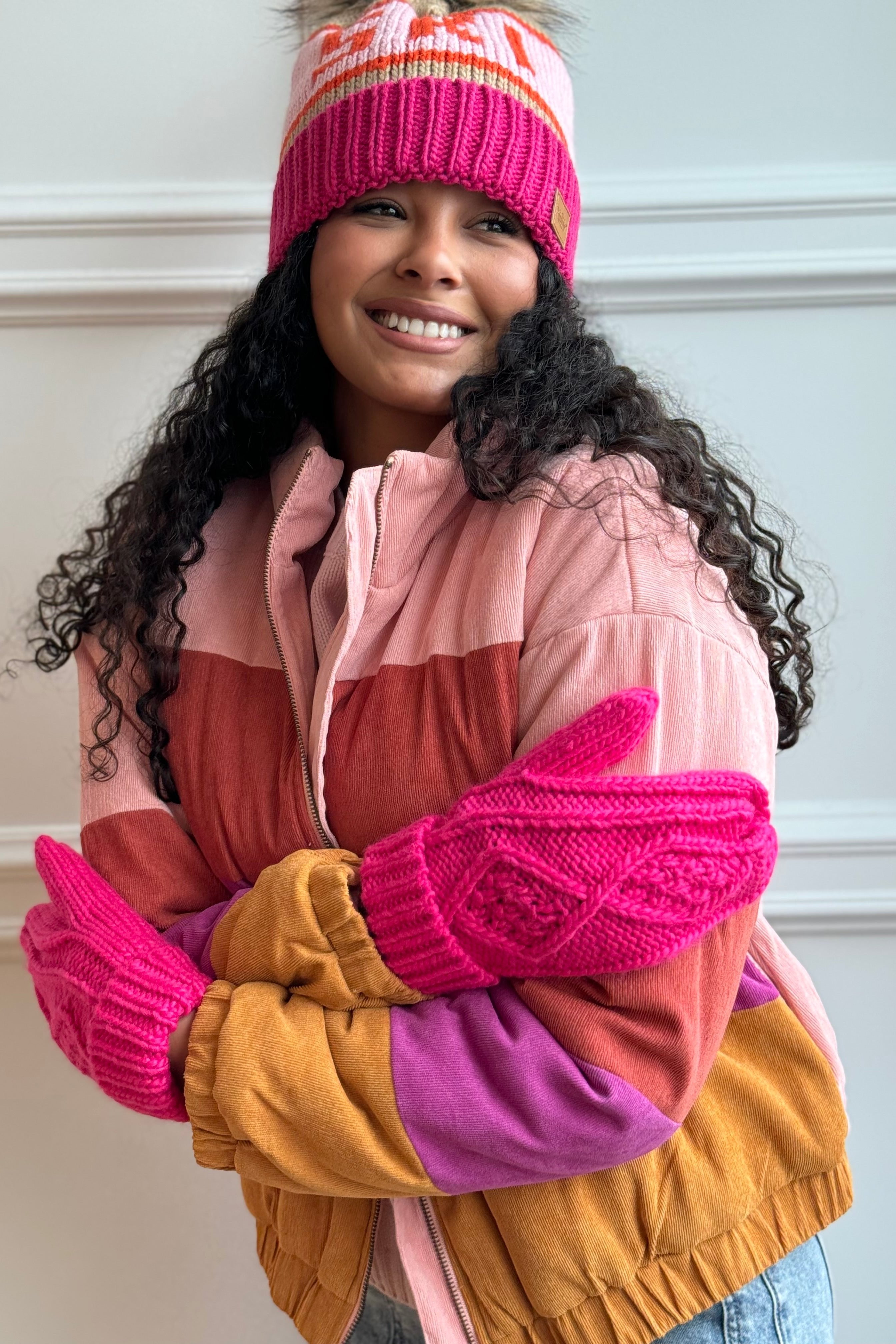 Girl hugging herself with mittens on 