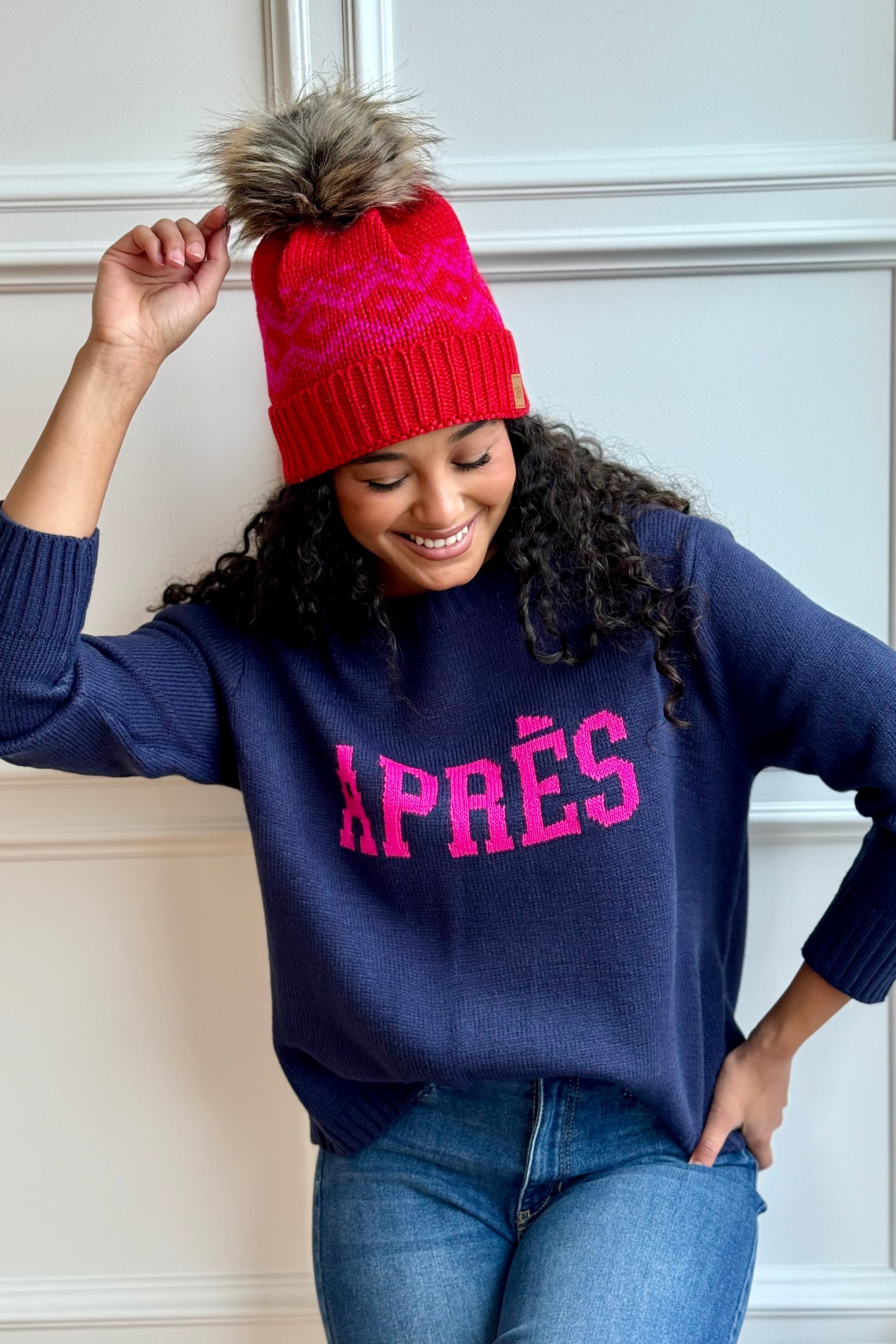 Woman looking down with hat and ski sweater on.