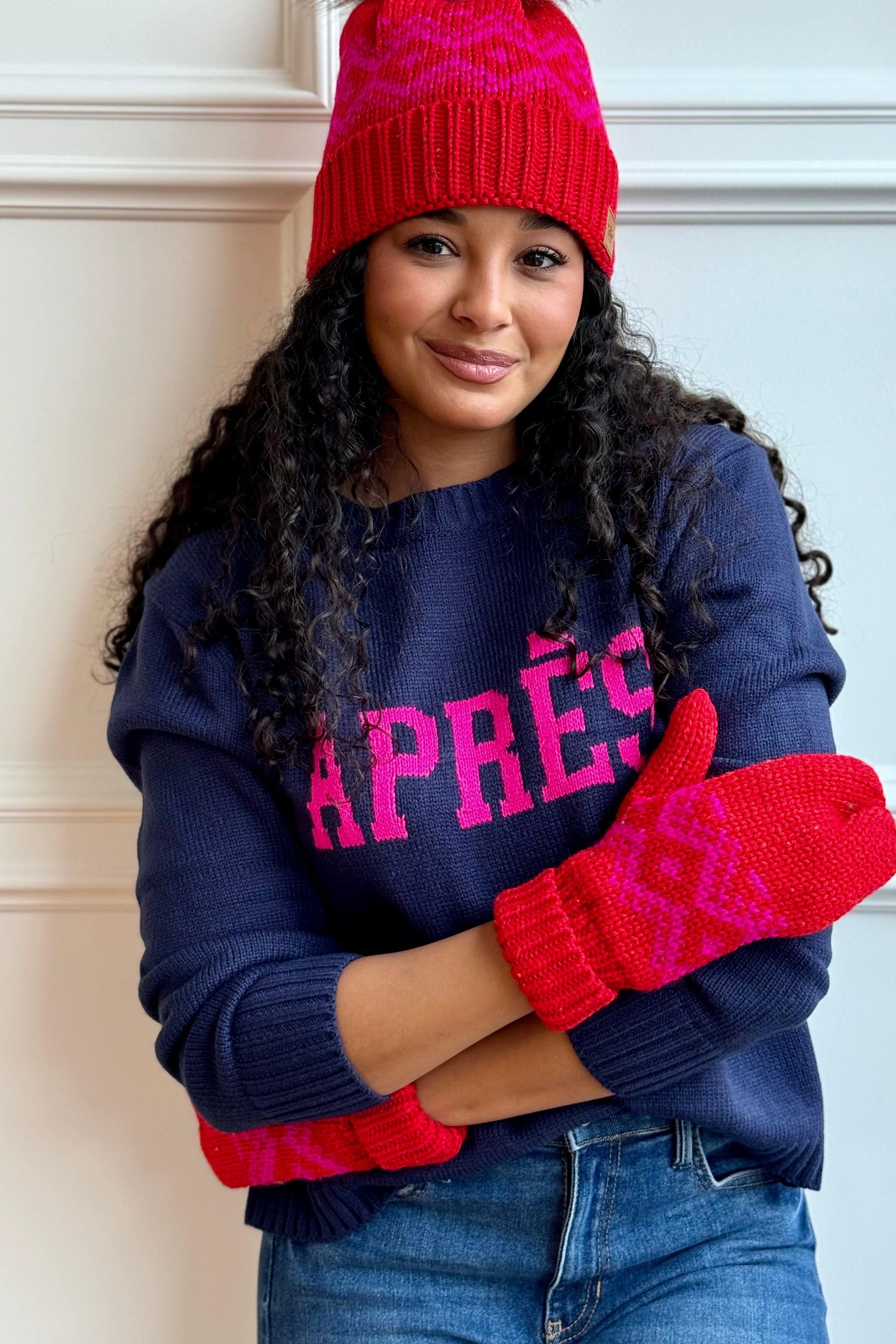 Woman hugging herself with mittens hat and sweater. 