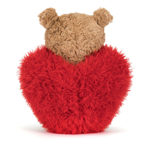 Stuffed animal bear wearing red heart facing the back