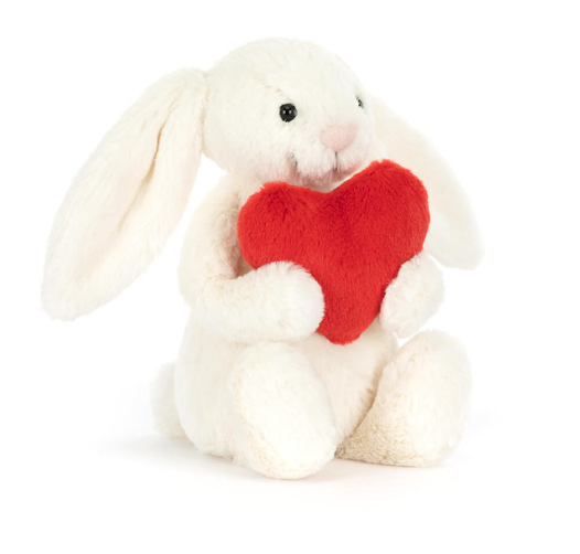 Stuffed bunny with floppy ears and holding a red heart