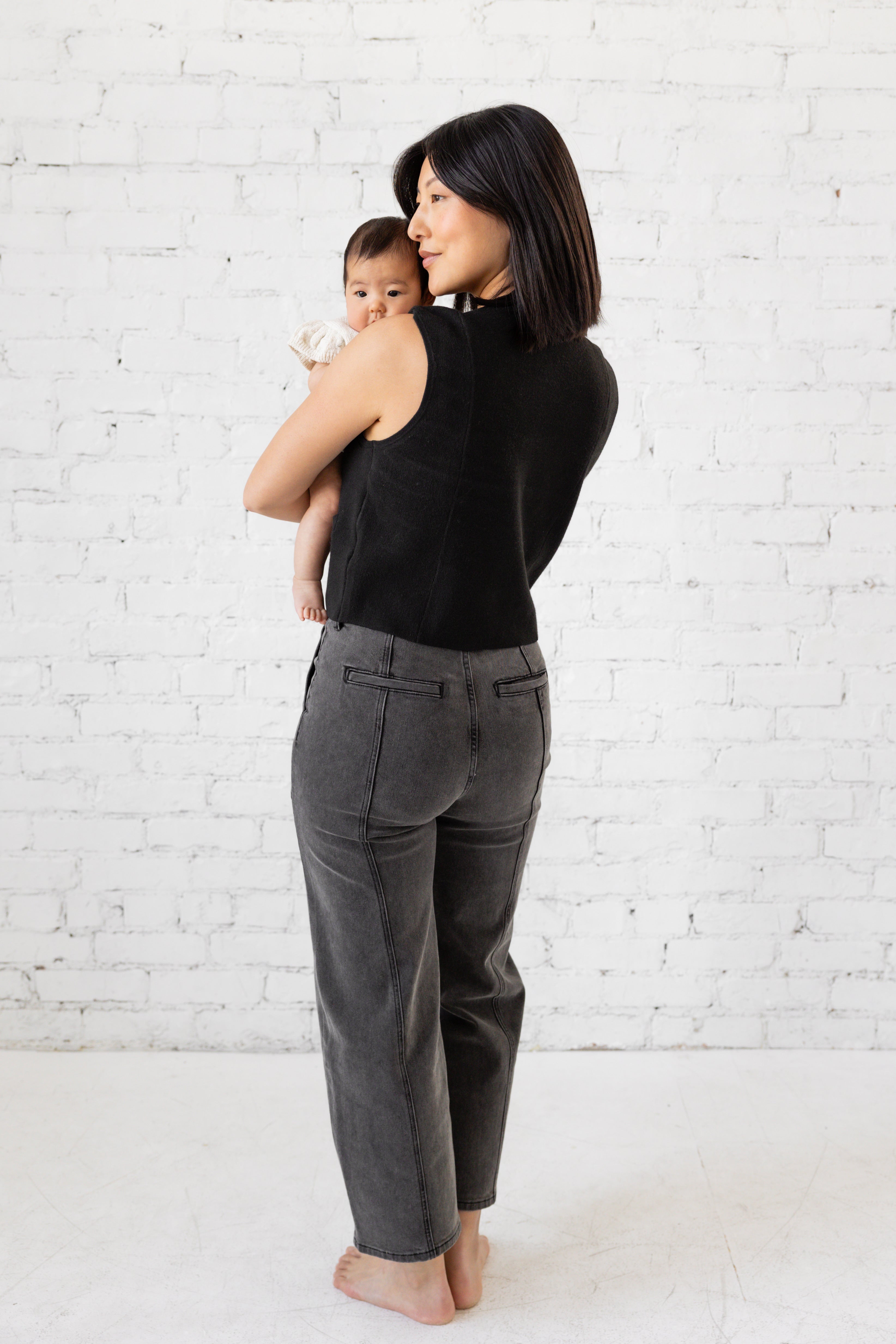 Model is wearing high waist black jeans with deep cargo pockets.