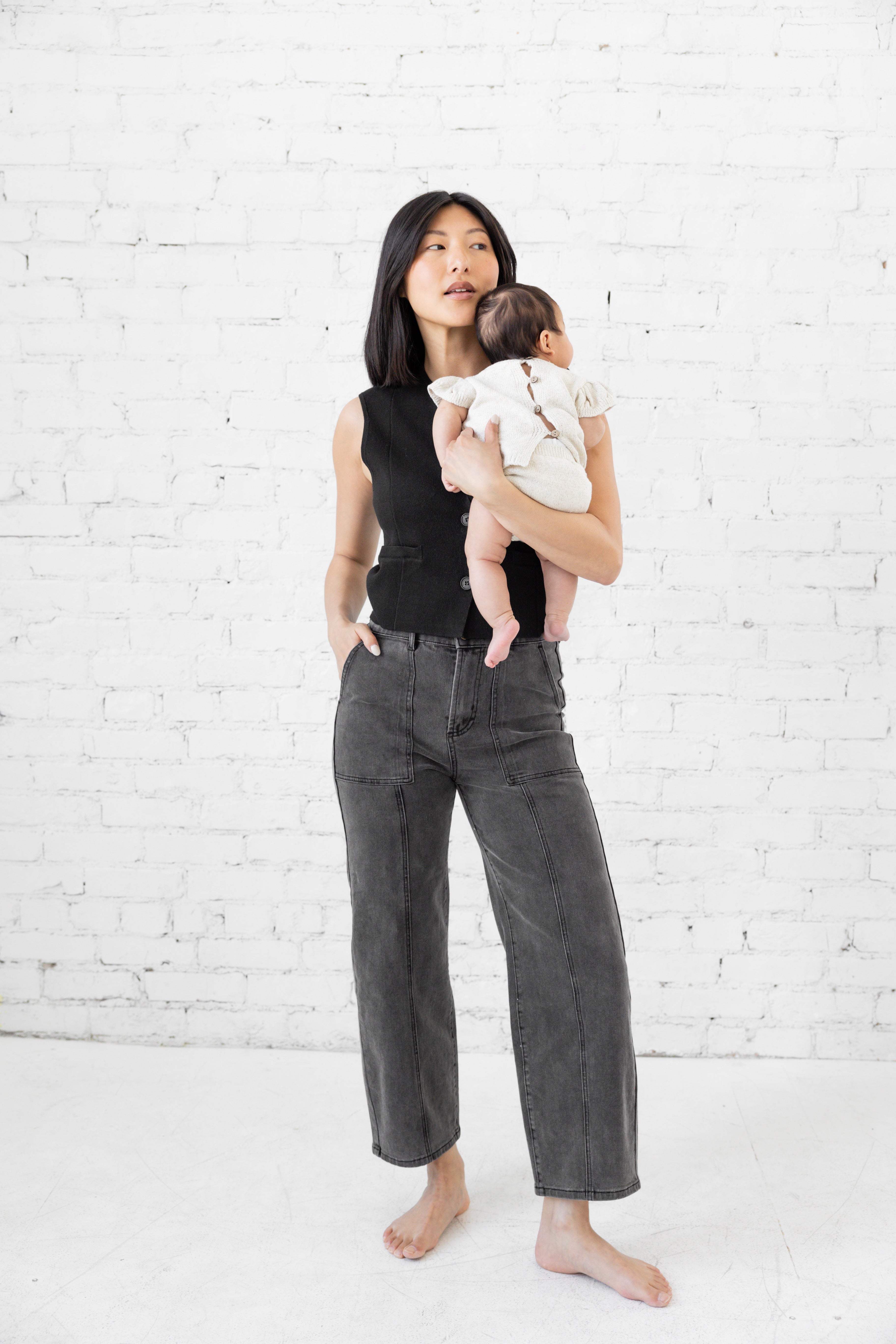 Model is wearing high waist black jeans with deep cargo pockets. 