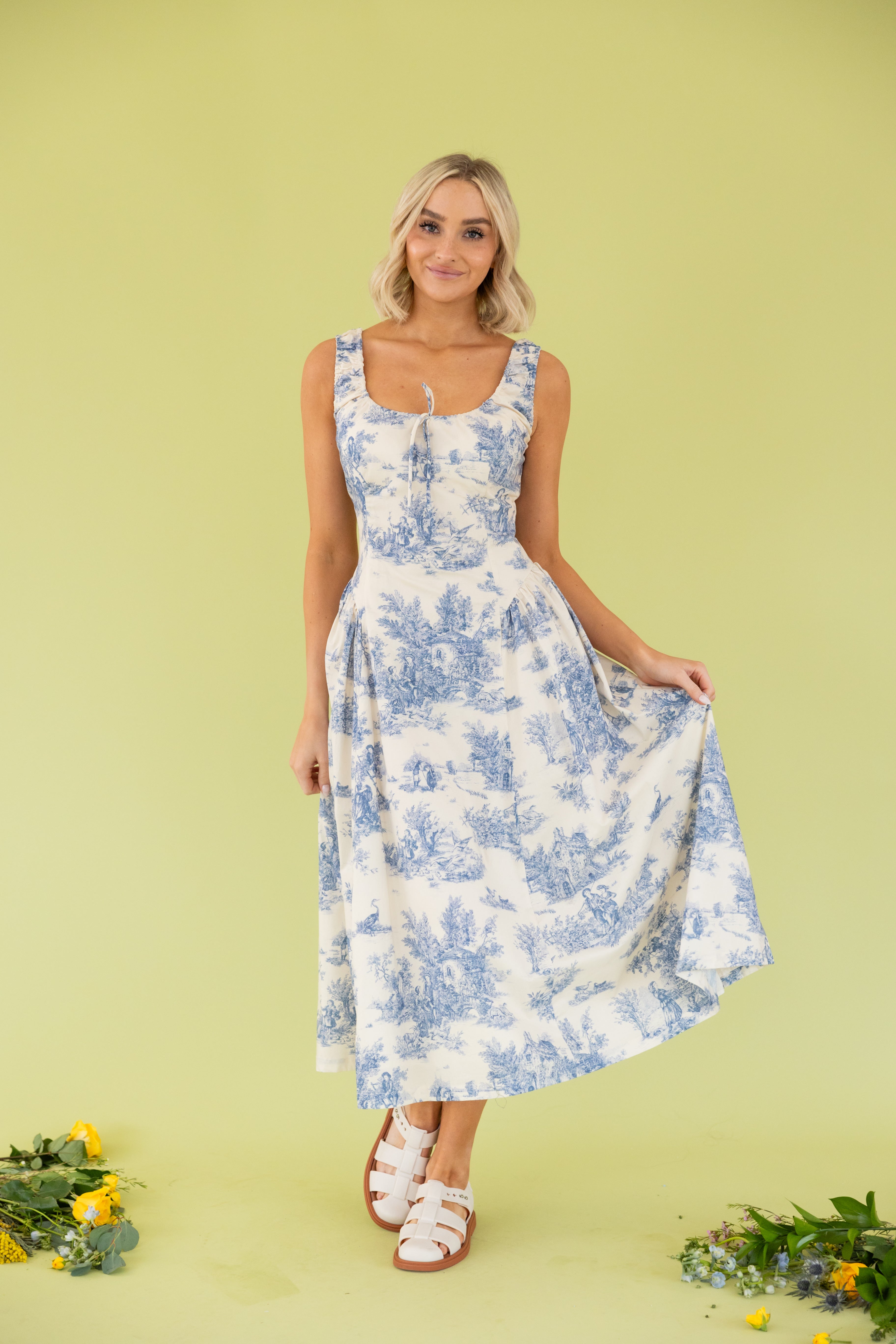 Model is wearing tank blue and white midi dress.