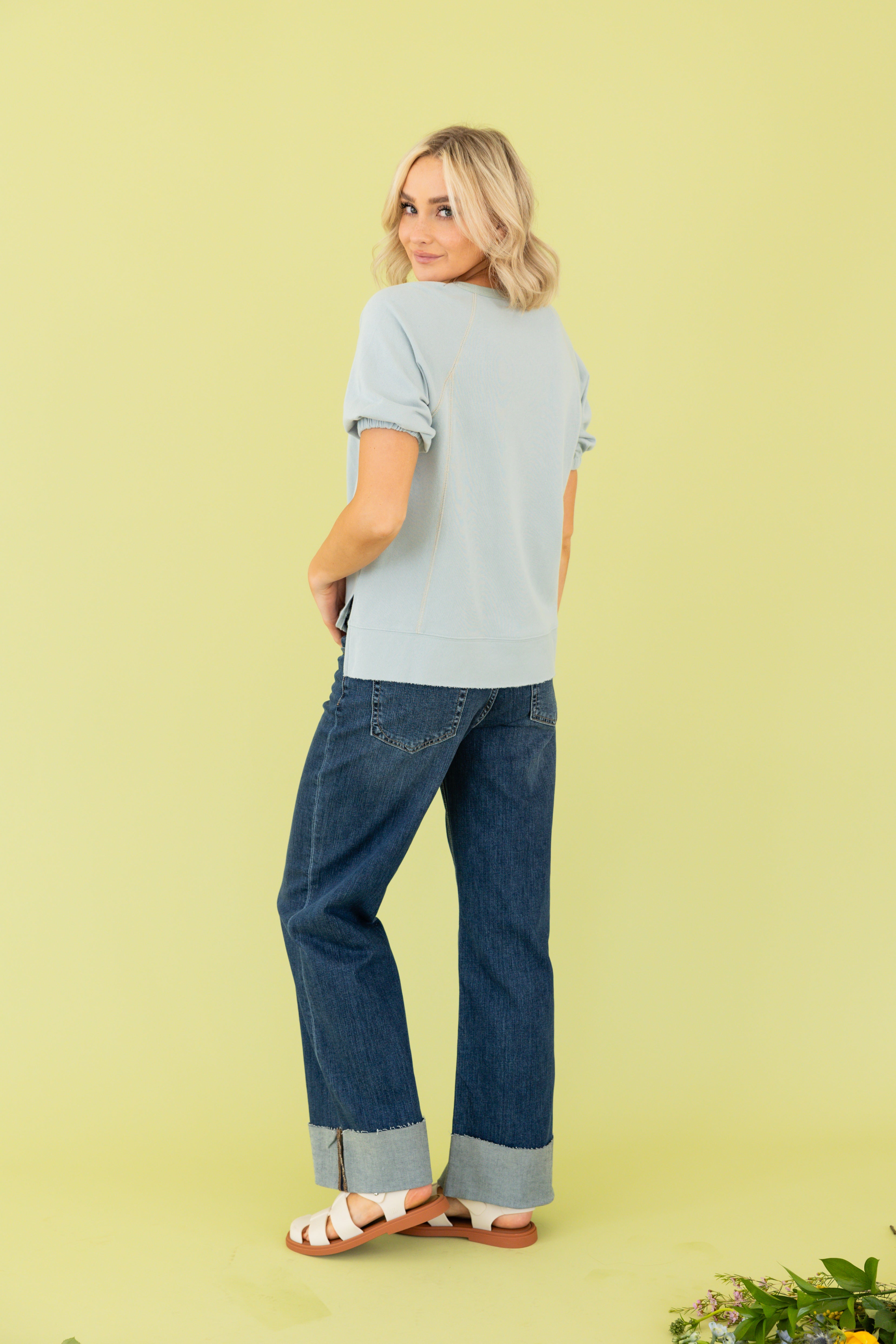 Model is wearing a blue top and blue jeans.