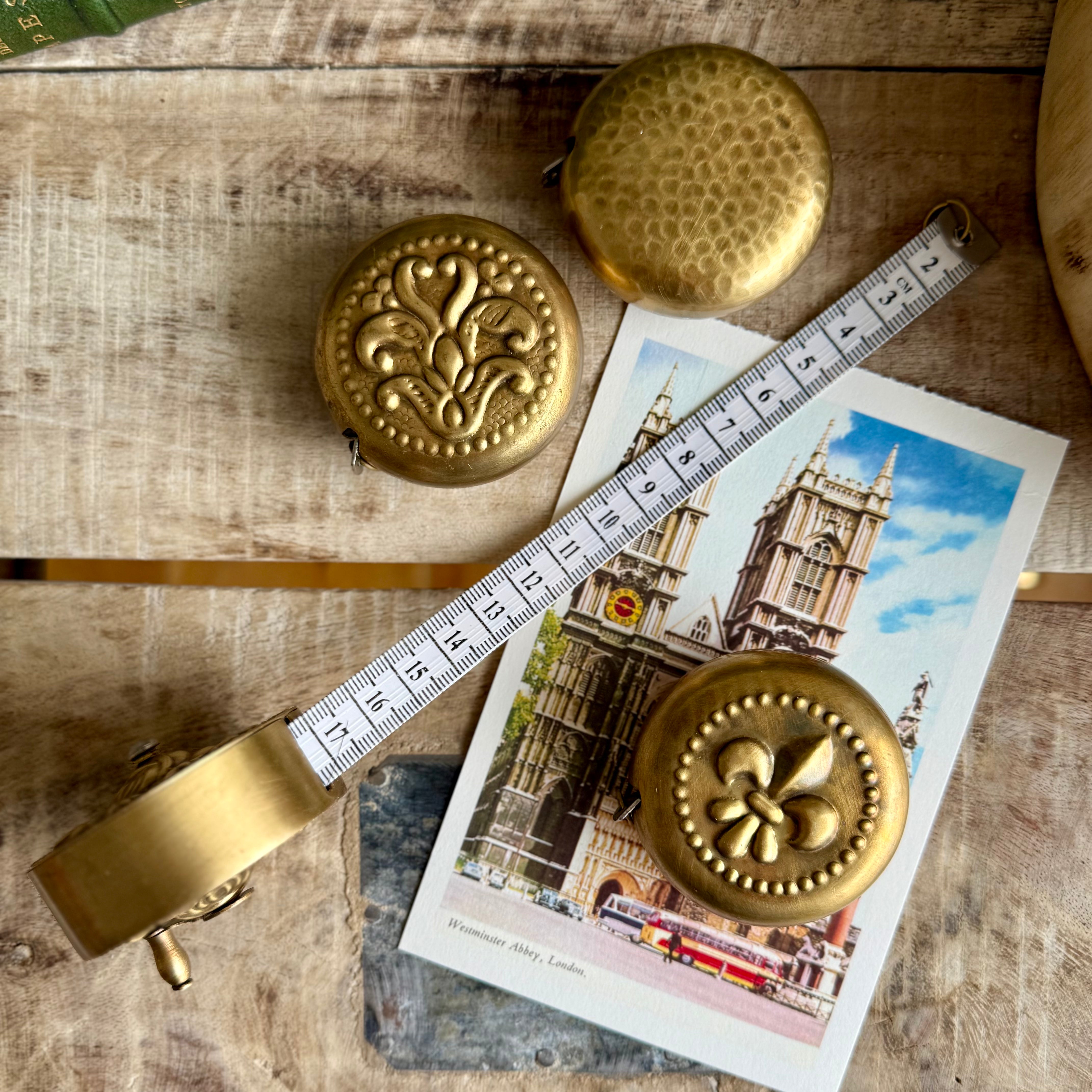 Product shoot of vintage brass measuring tapes.  