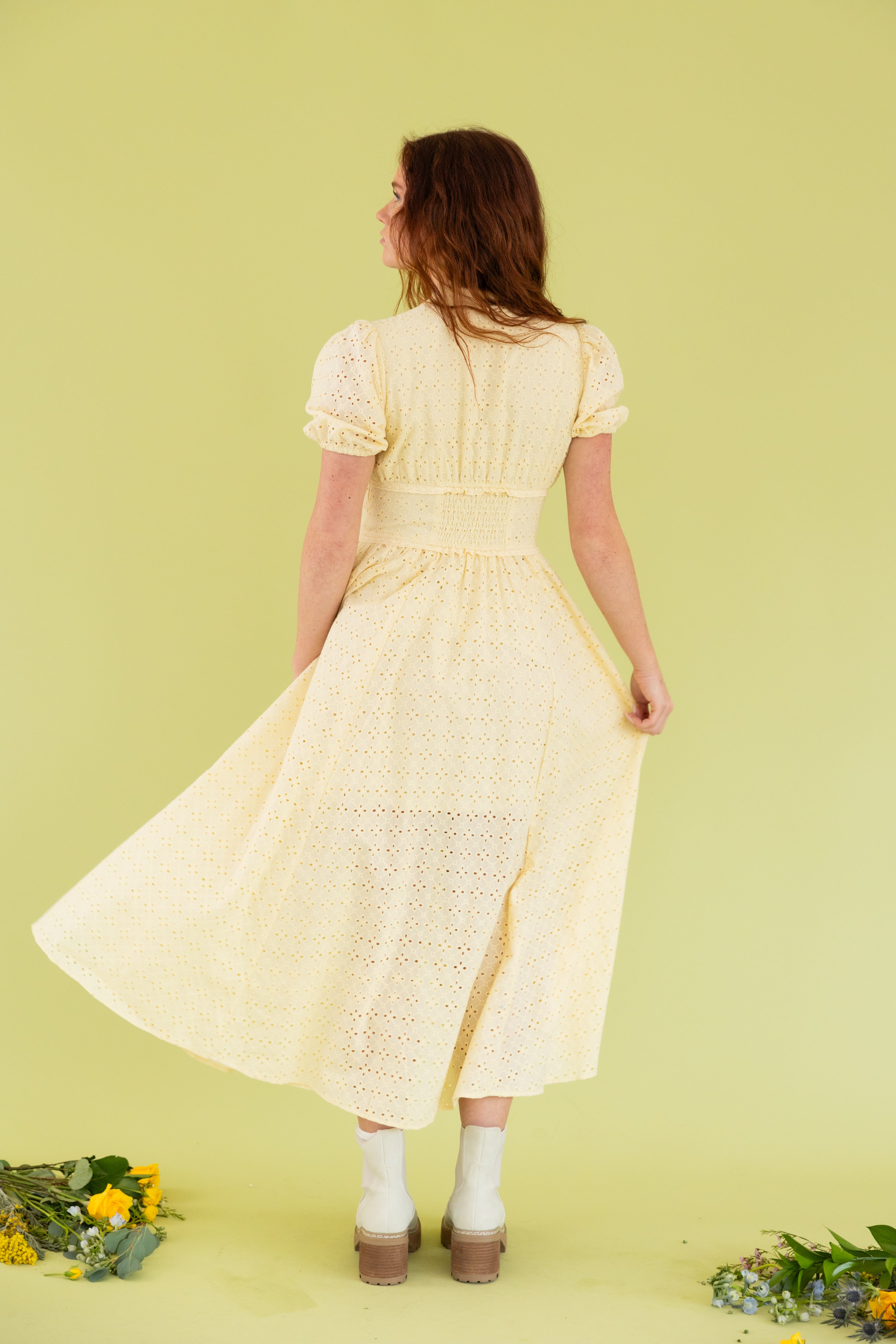 Model is wearing puff sleeve yellow lace midi dress. 