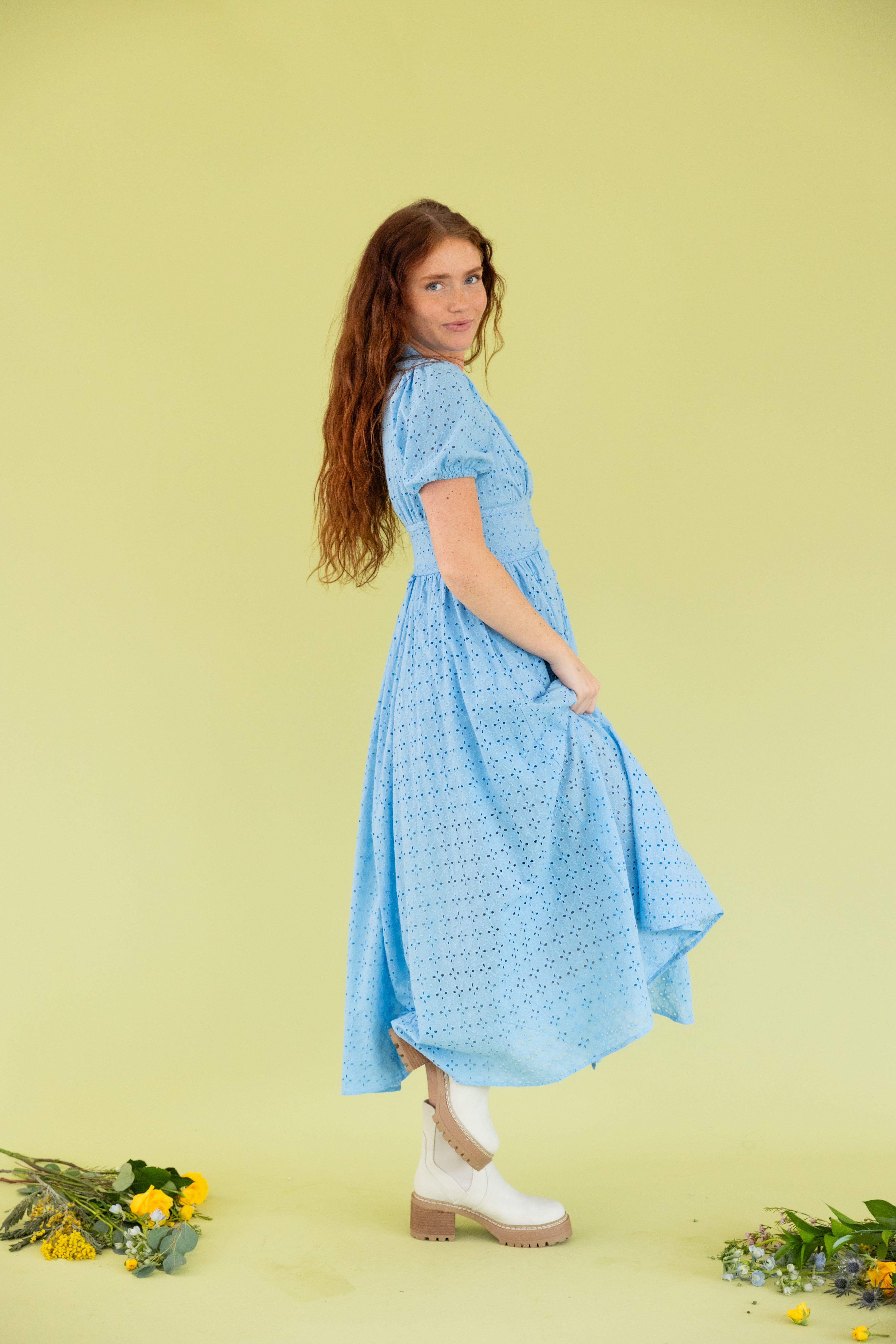 Model is wearing puff sleeve blue lace midi dress. 