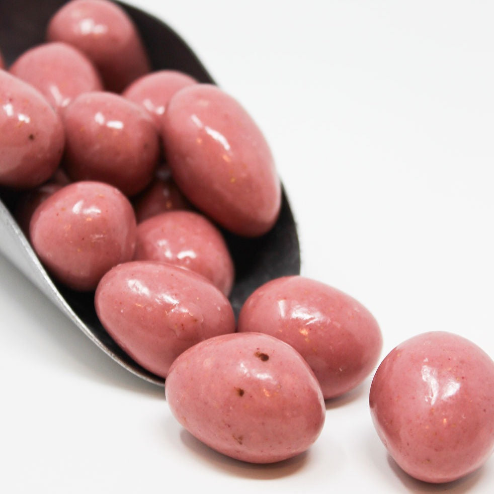 Chocolate pink strawberries coming out of a scoop.