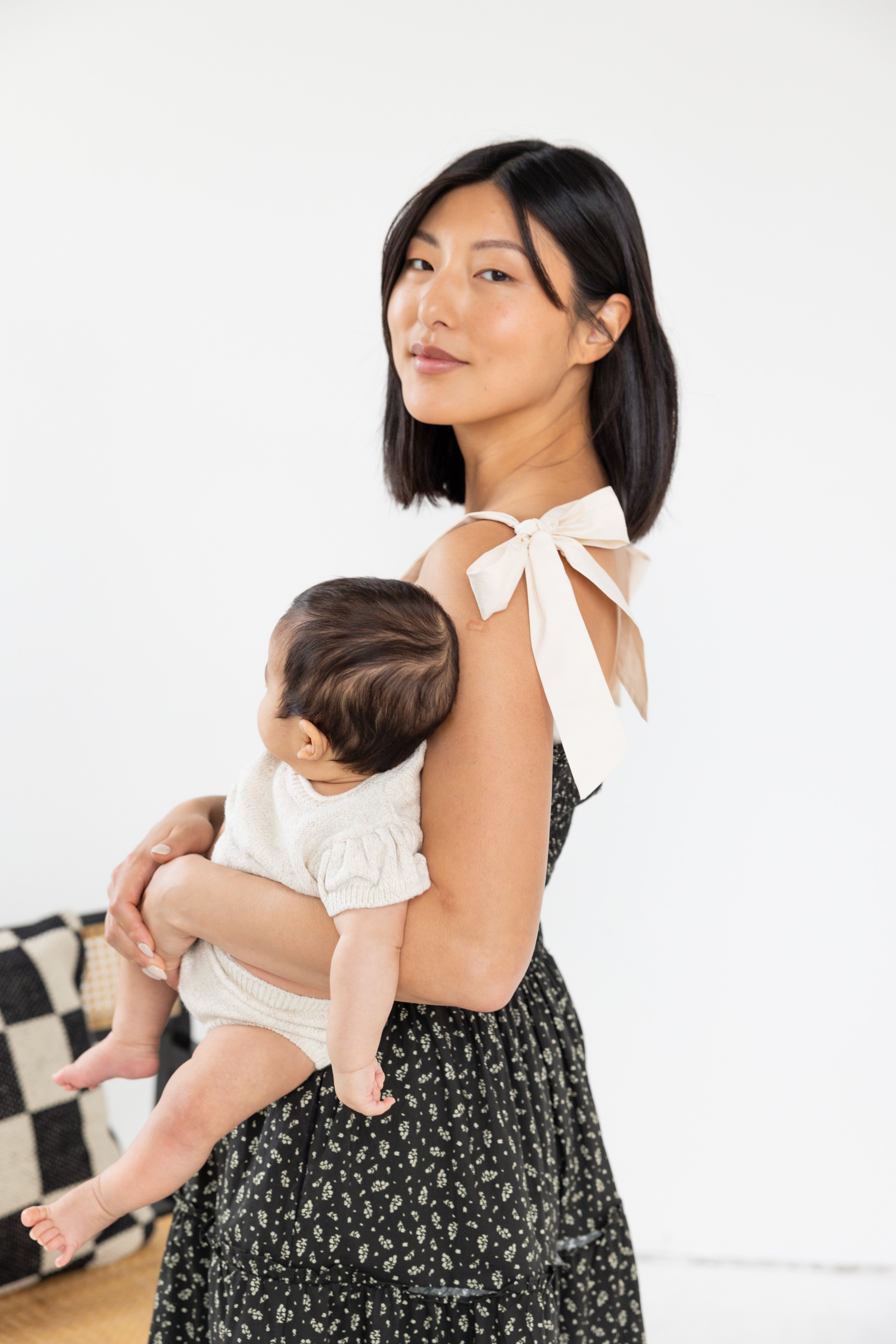 Model is wearing midi floral dress with tank tied bows.