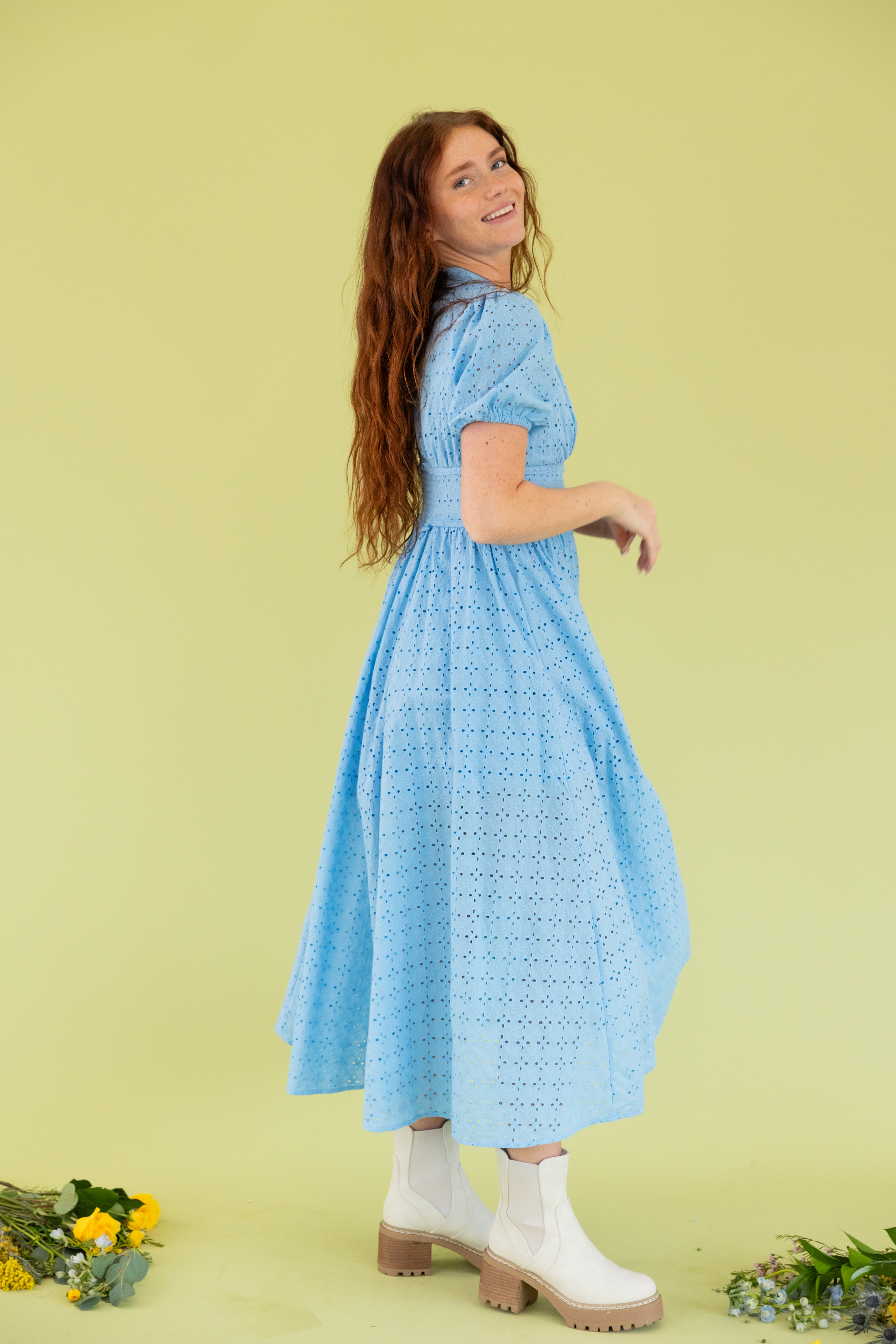 Model is wearing puff sleeve blue lace midi dress. 