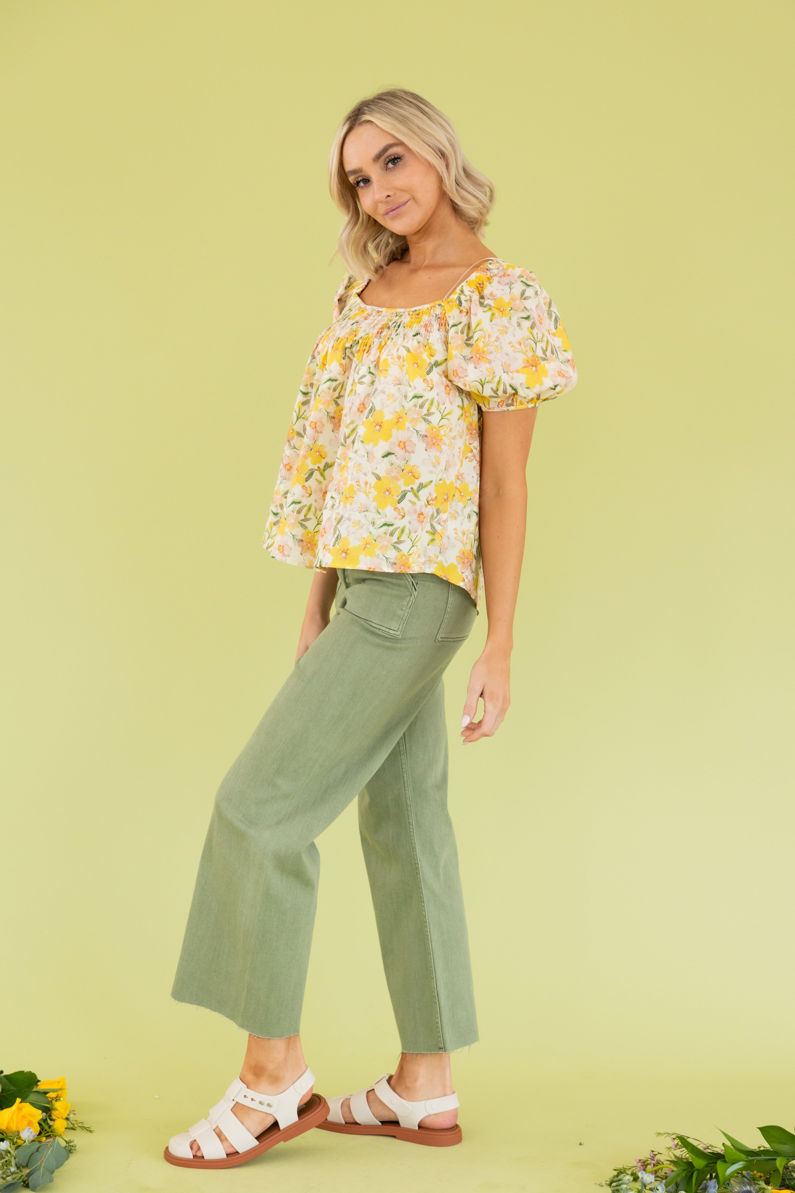 Model is wearing a yellow floral blouse and green wide leg pant.  