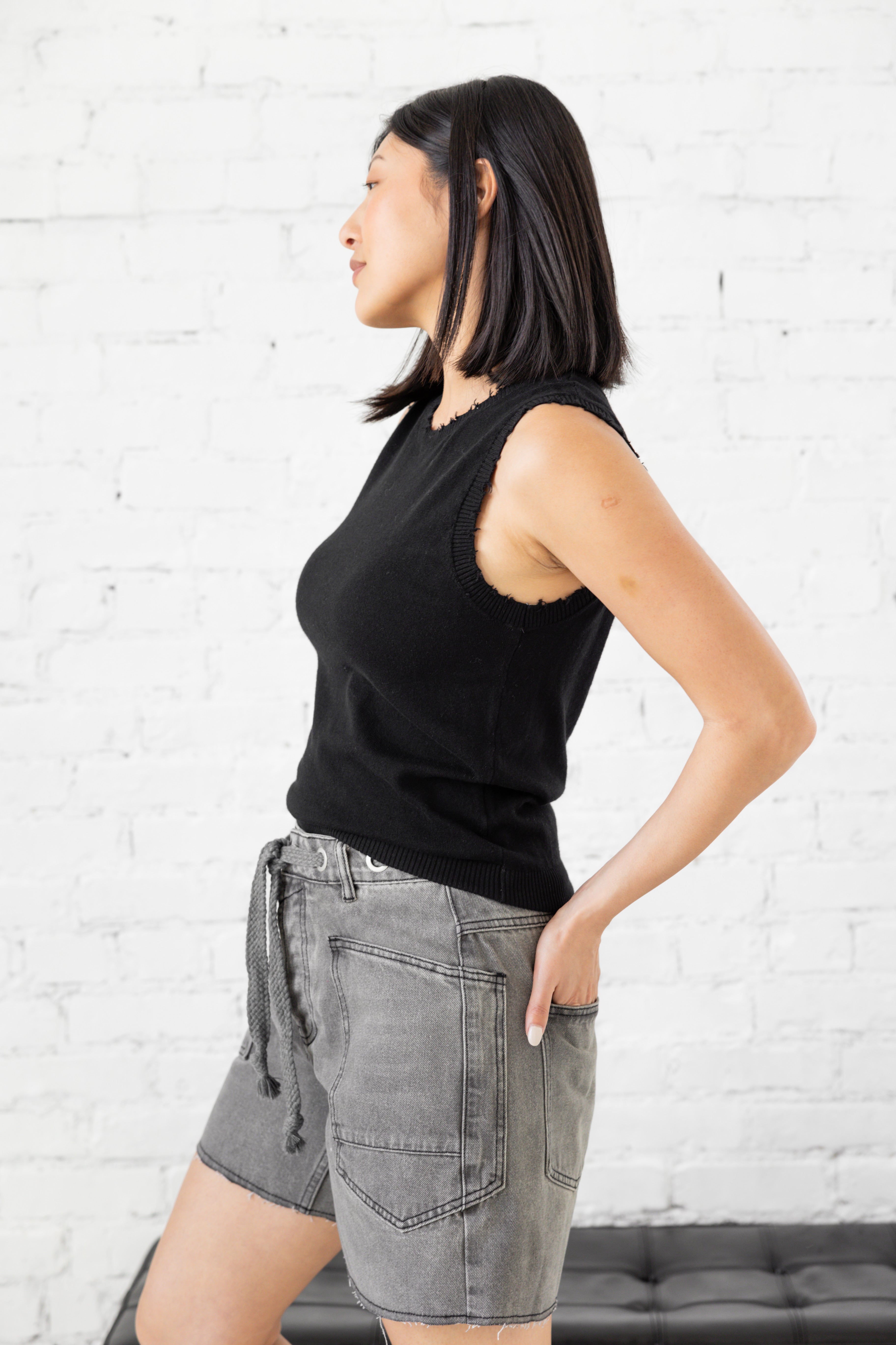 Model is wearing oversized high waist grey shorts with drawstring tie belt and large pockets. 