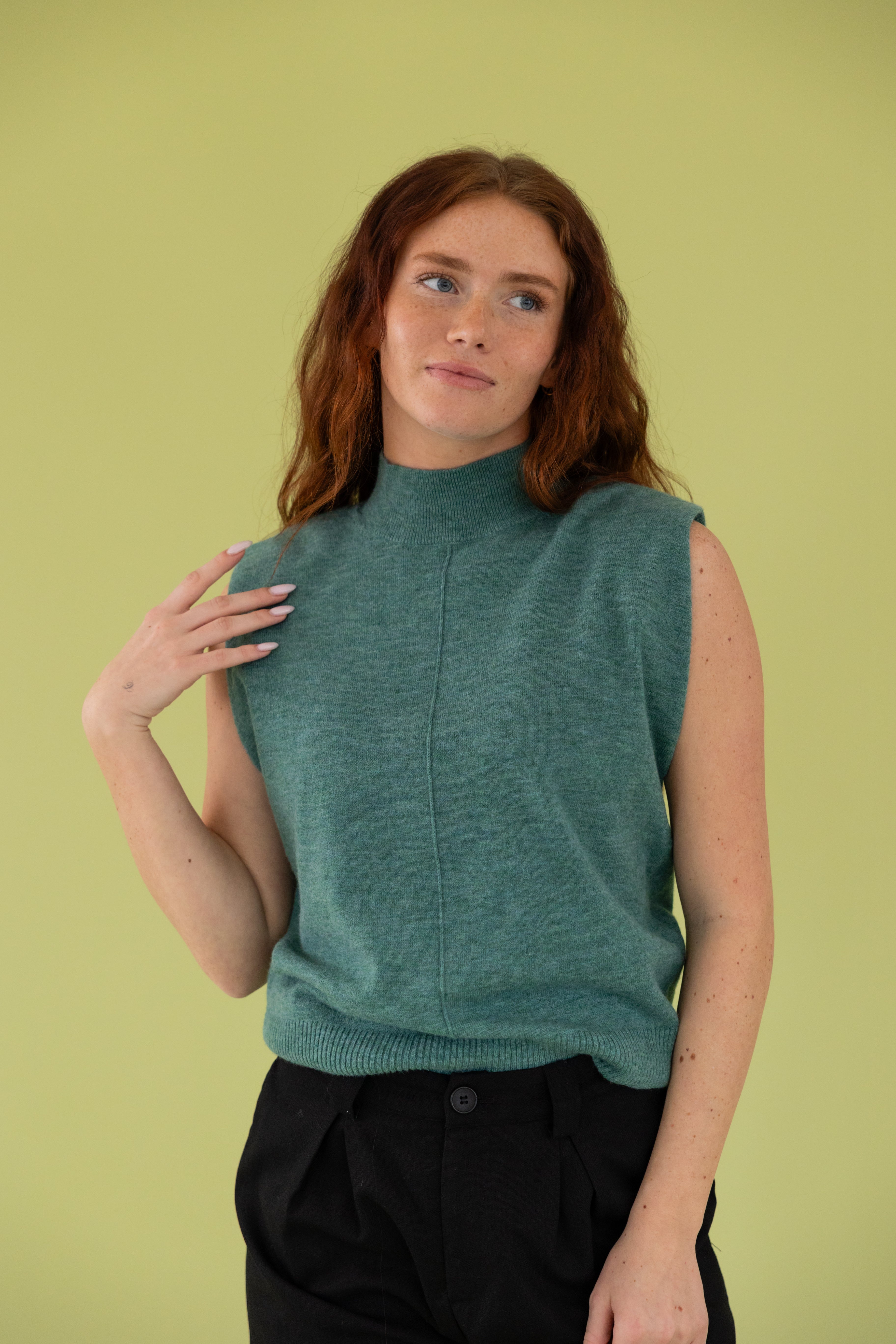 Model is wearing a high neck sweater top.