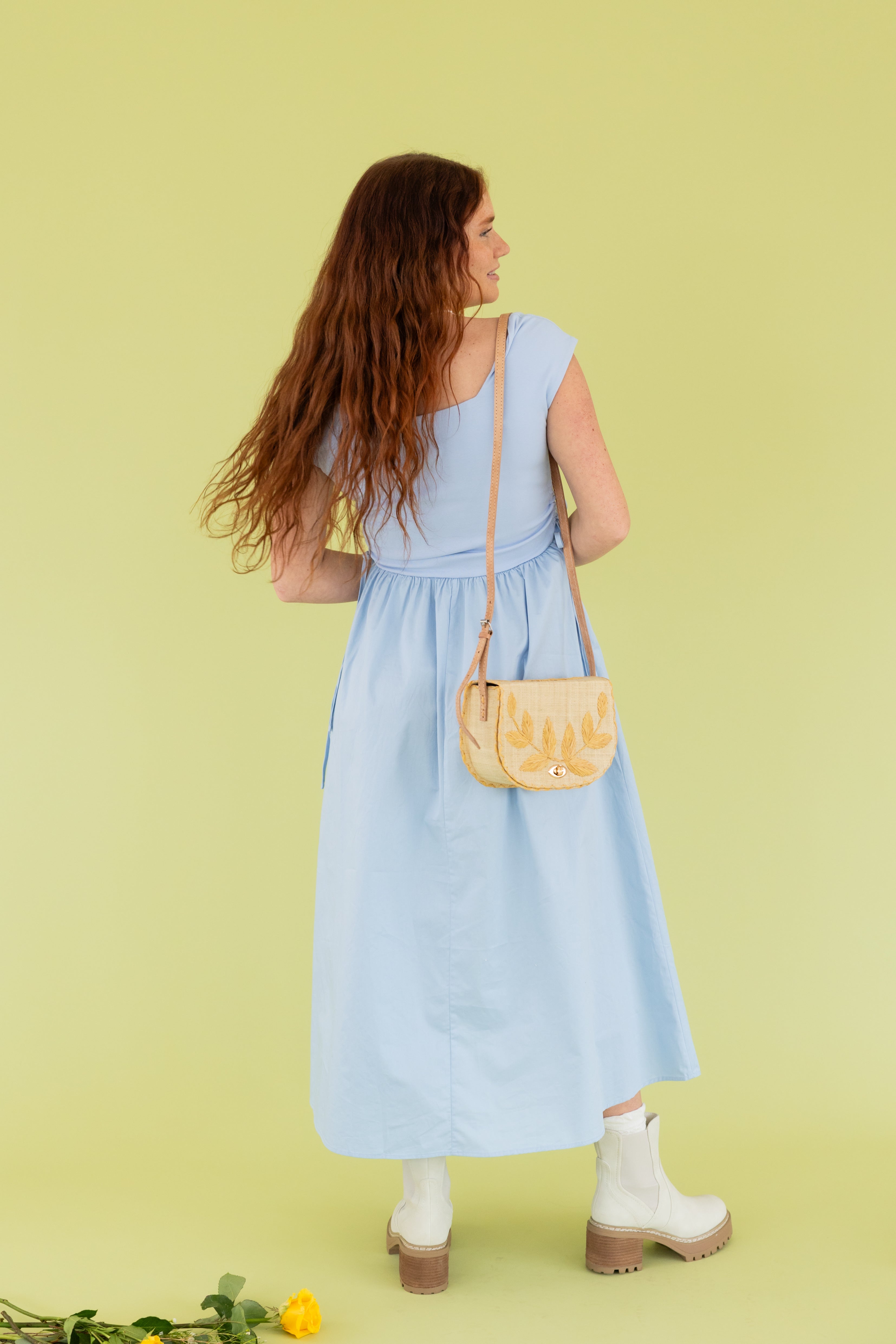 Model is wearing a blue dress at a photoshoot.