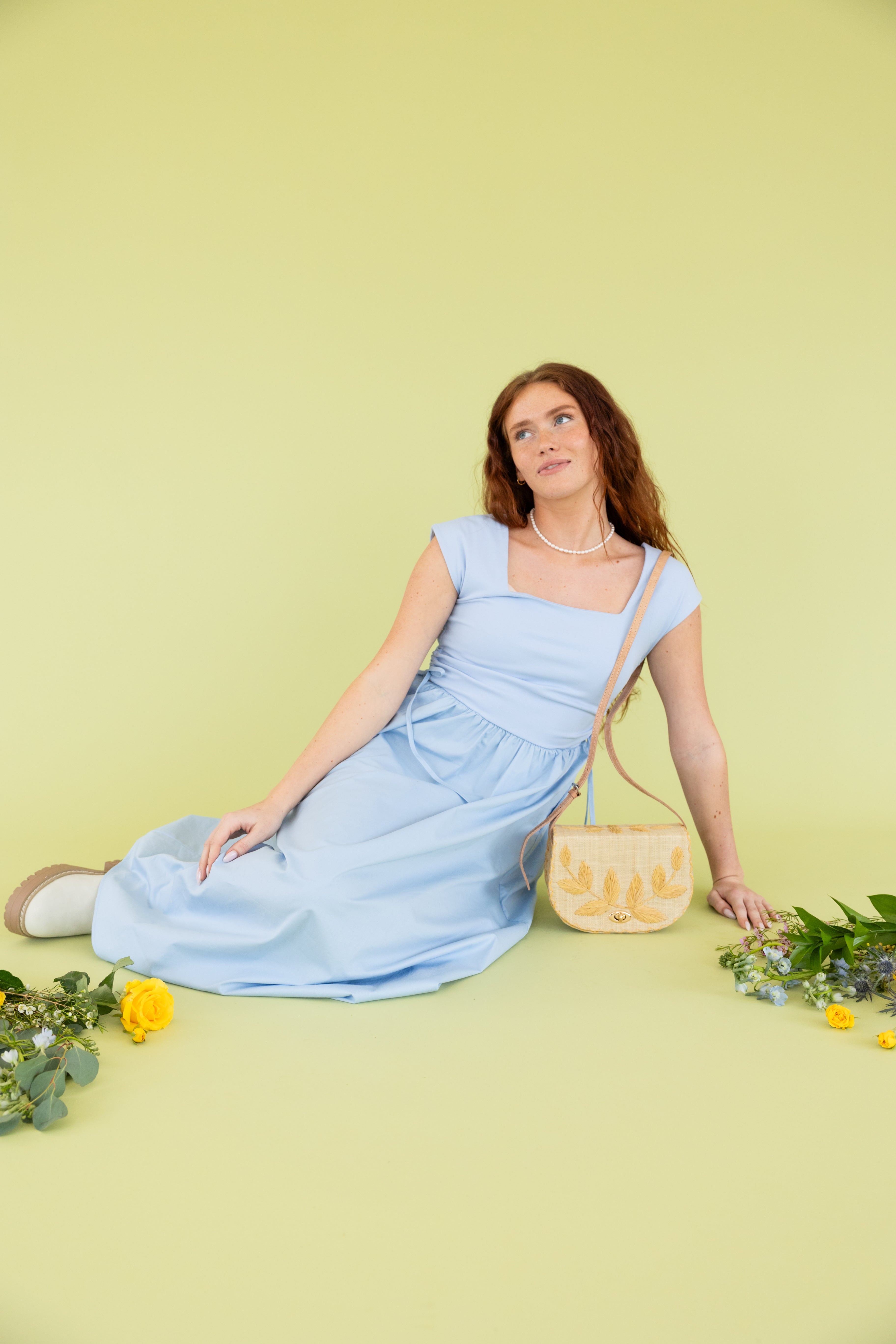 Model is wearing a blue dress at a photoshoot.