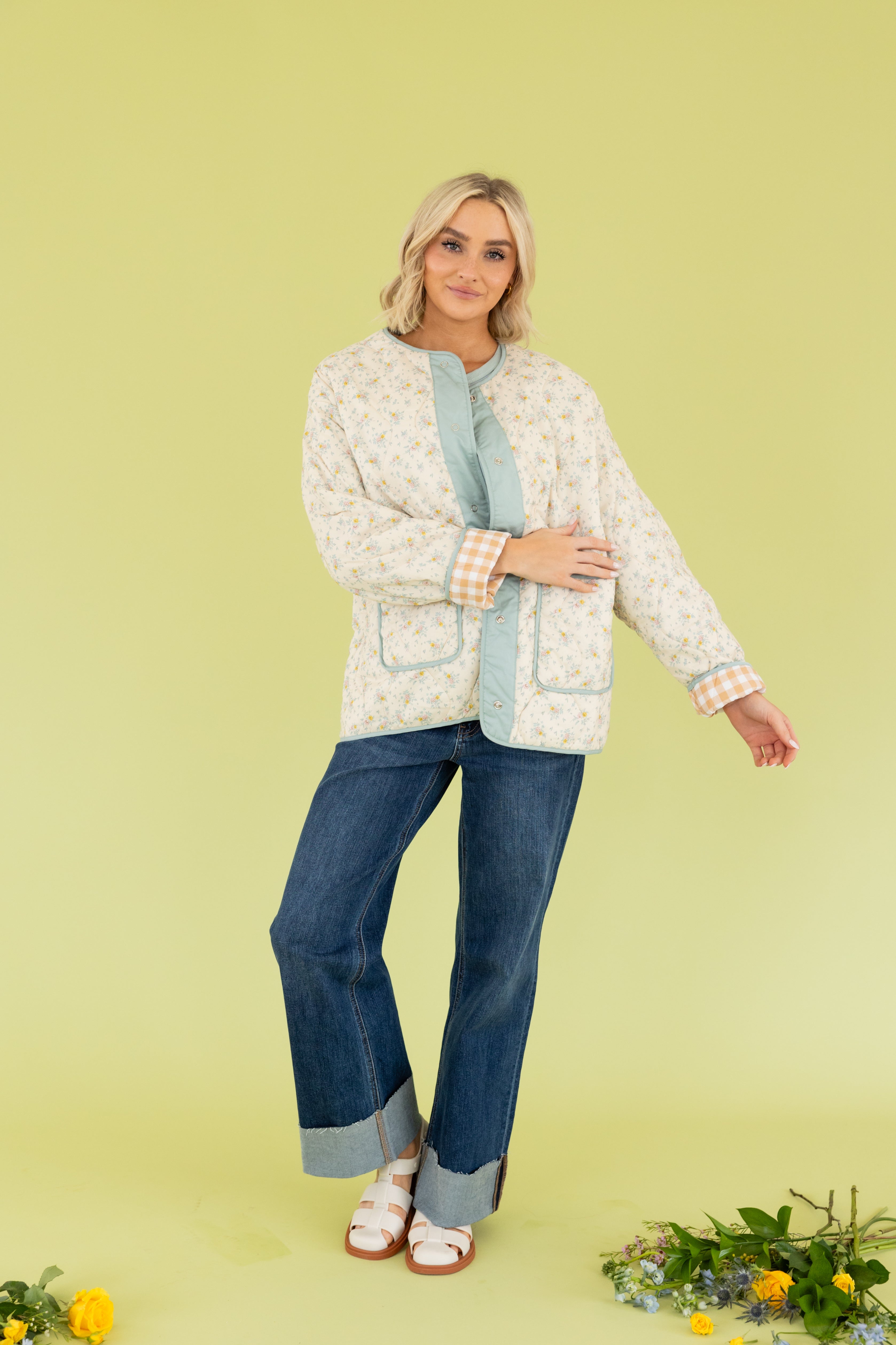 Model is wearing a quilted jacket and jeans.