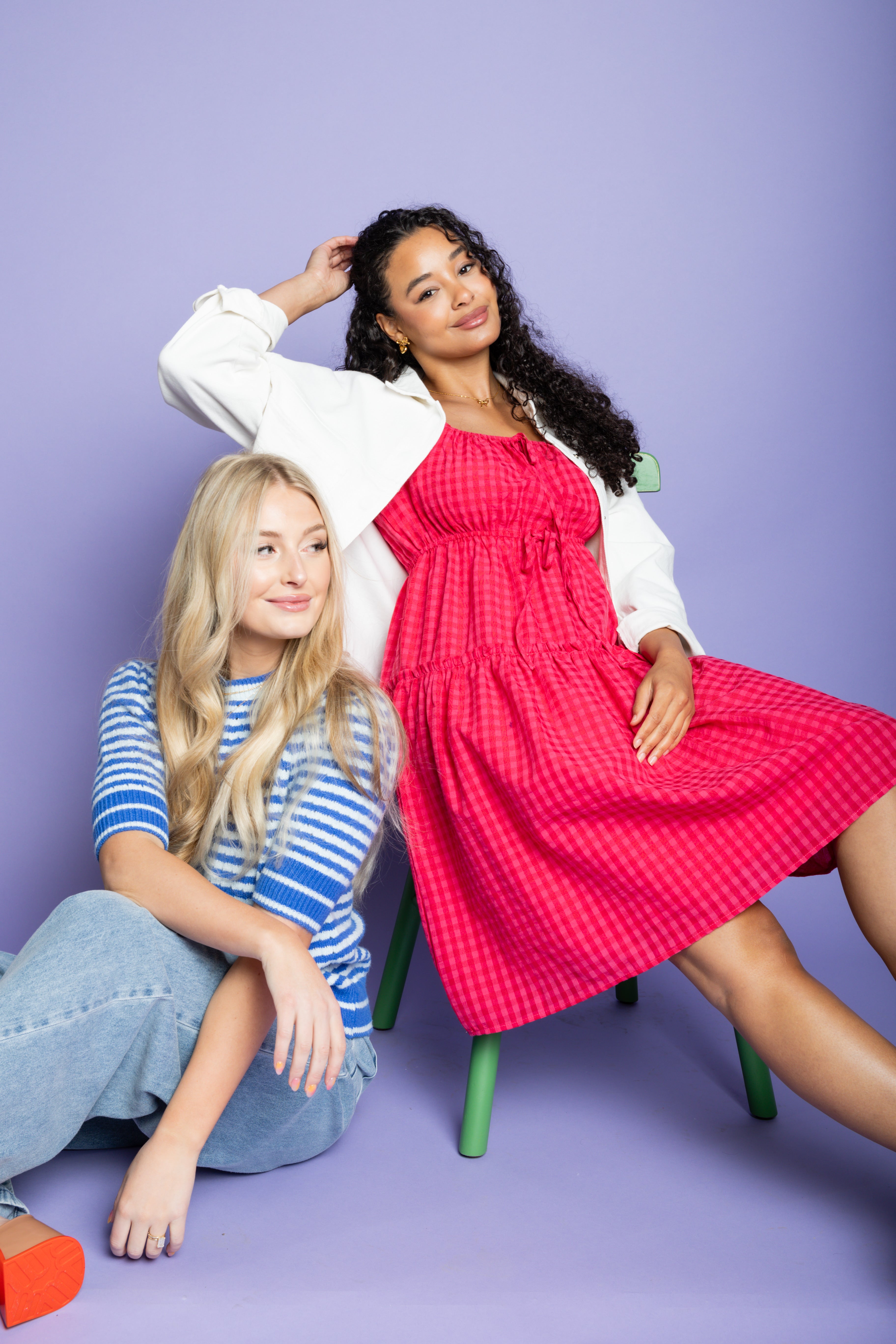 Model is wearing white collared jacket and pink dress.