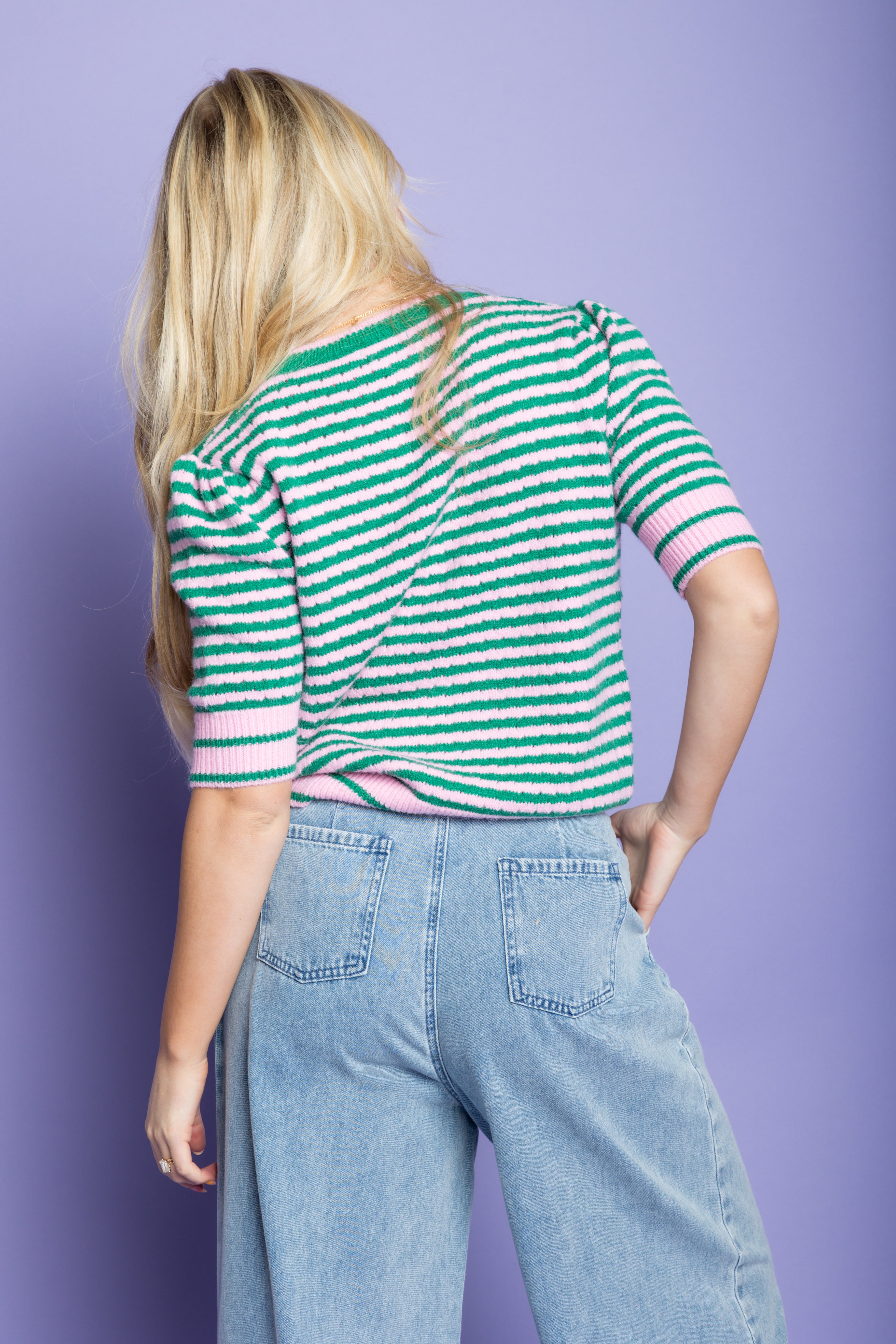 Model is wearing a striped green sweater top 