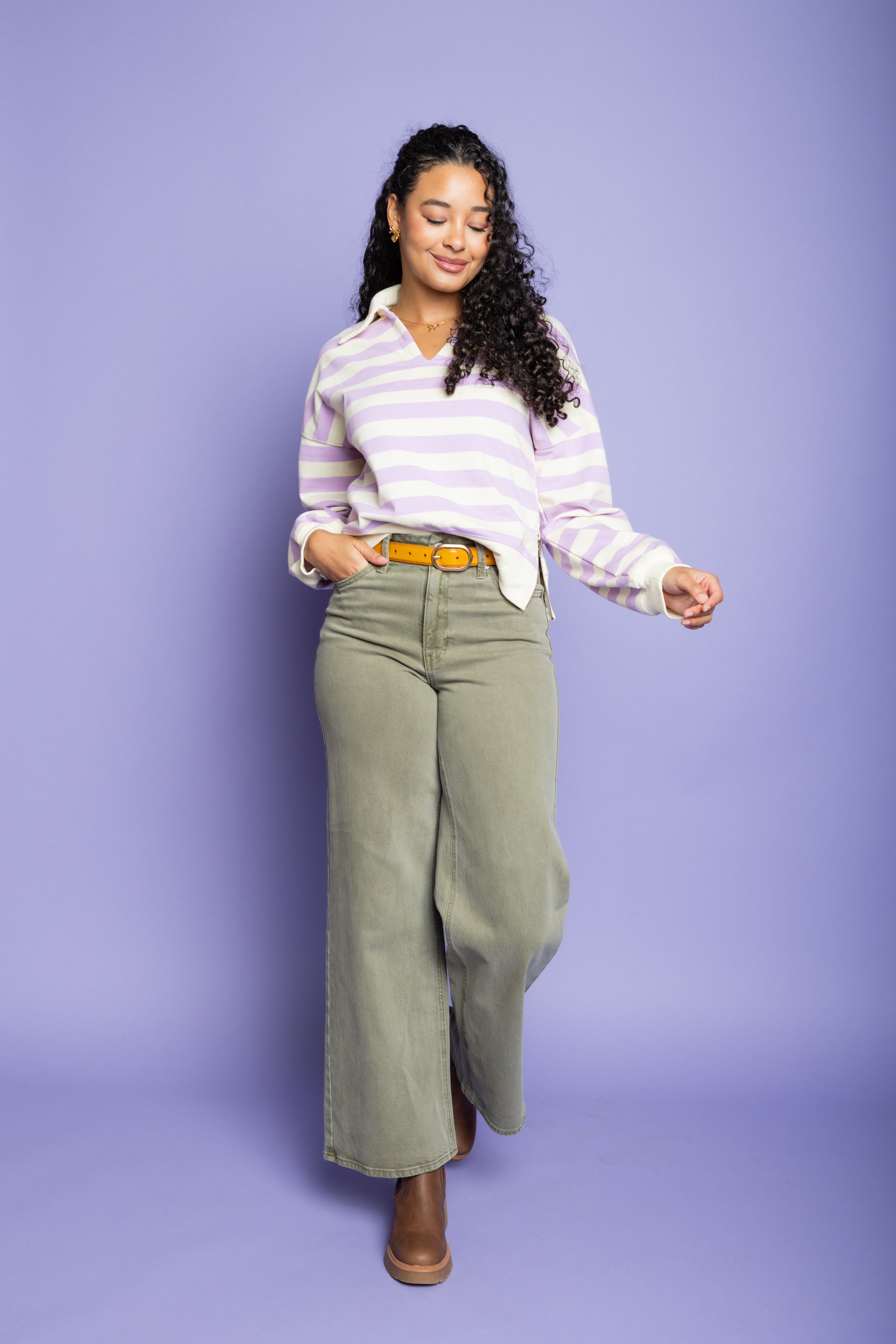 Model is wearing green wide leg pants with striped purple top 