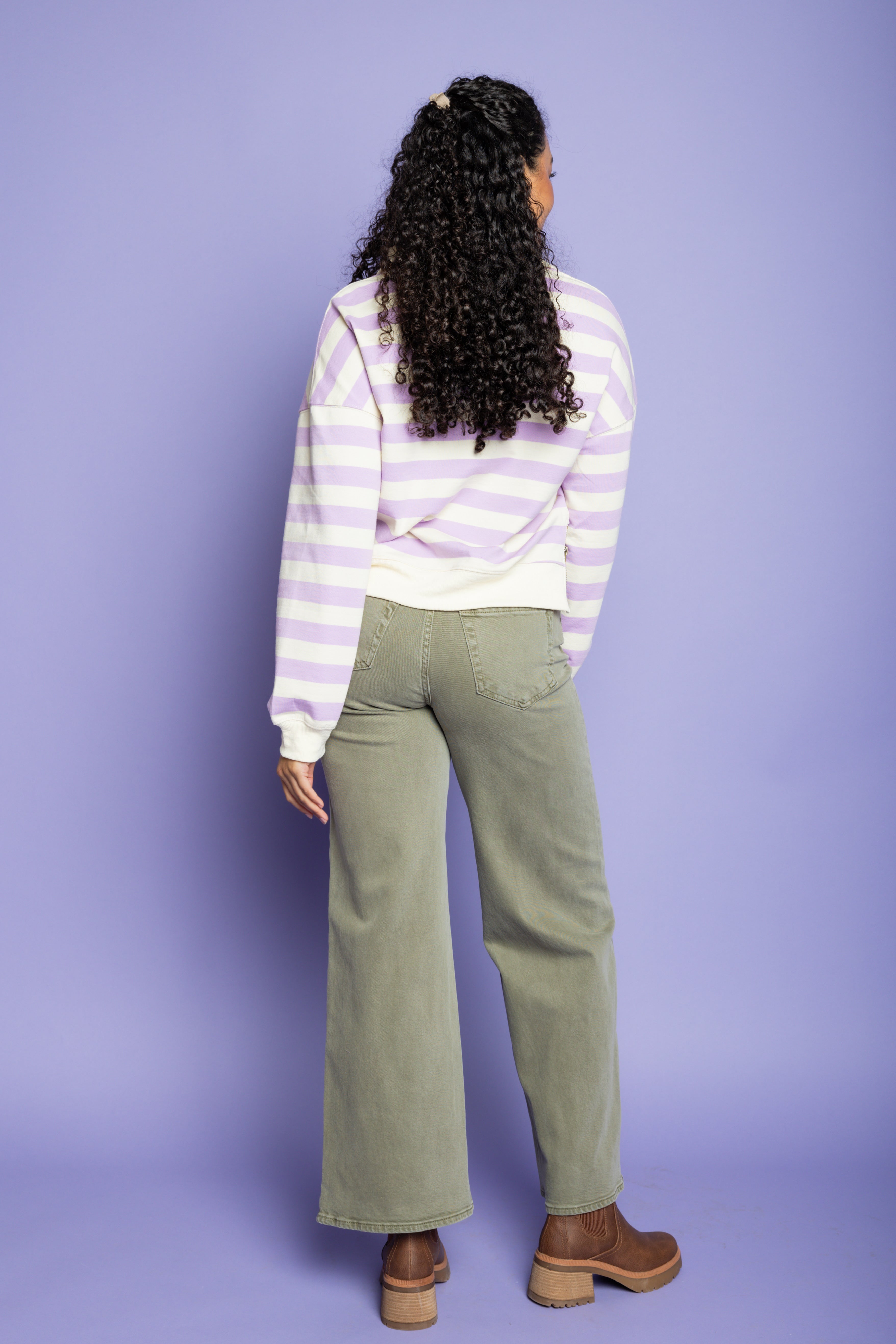 Model is wearing green wide leg pants with striped purple top