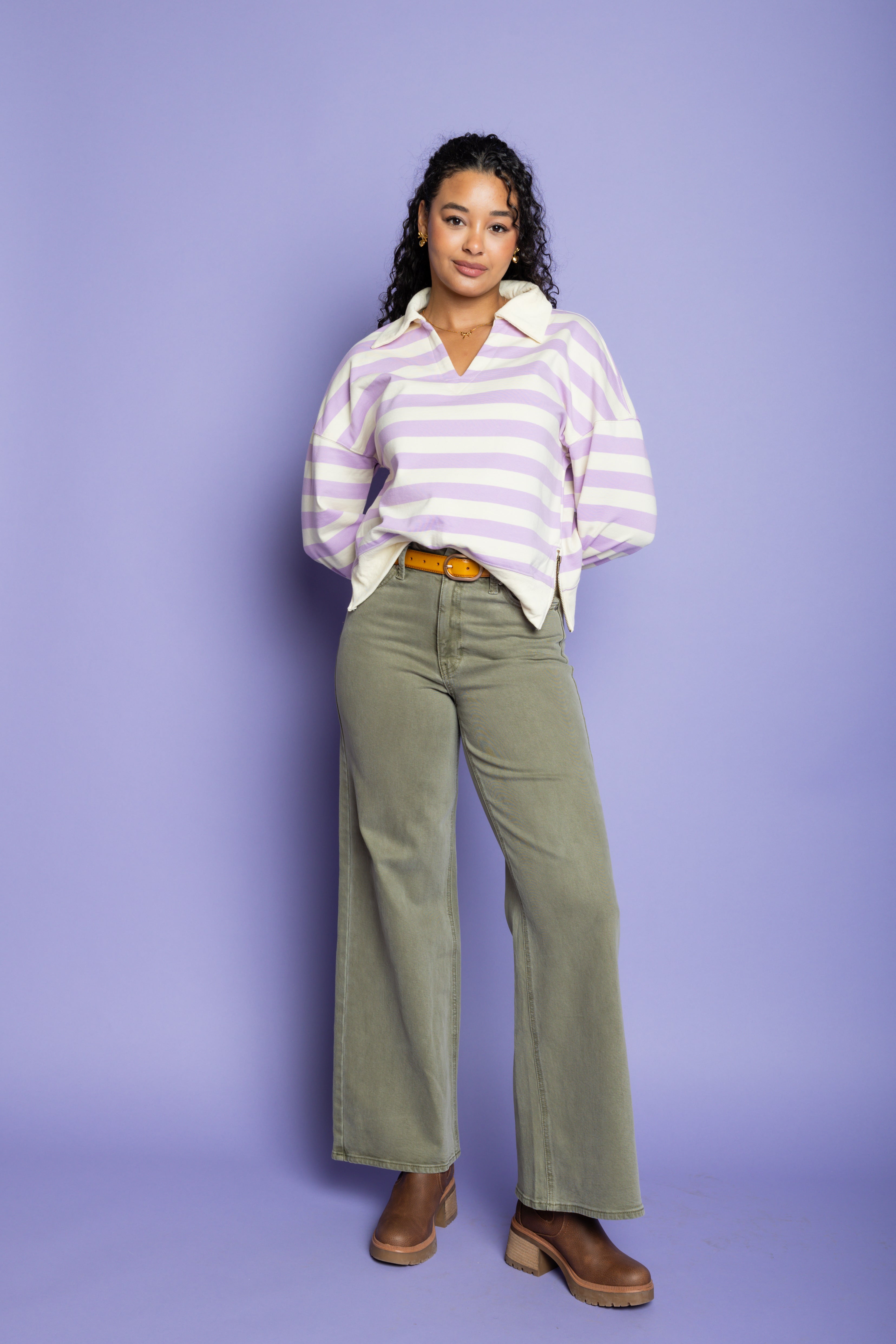 Model is wearing a purple striped top with green wide-leg pant