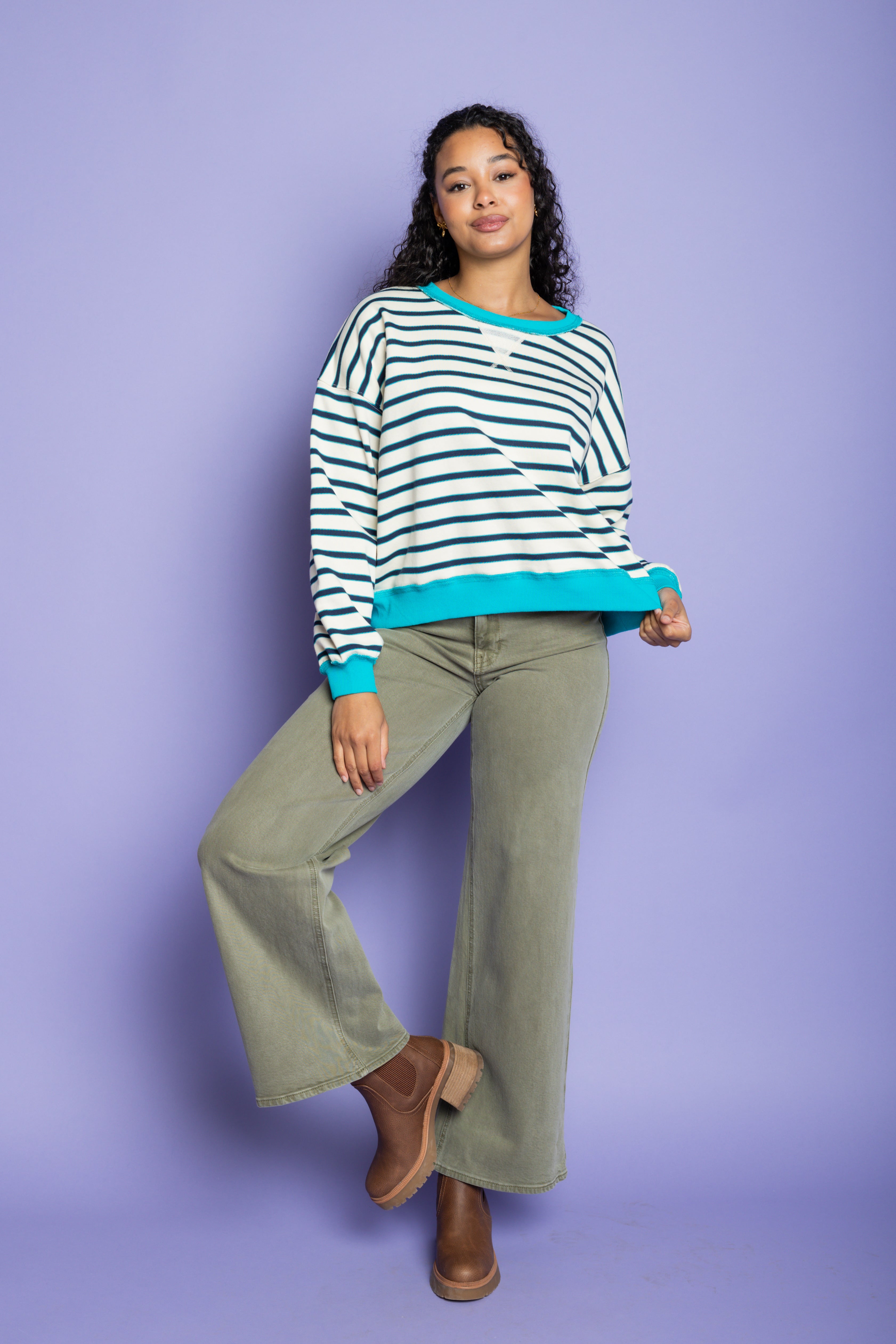 Model is wearing green wide leg pants with striped blue and white top