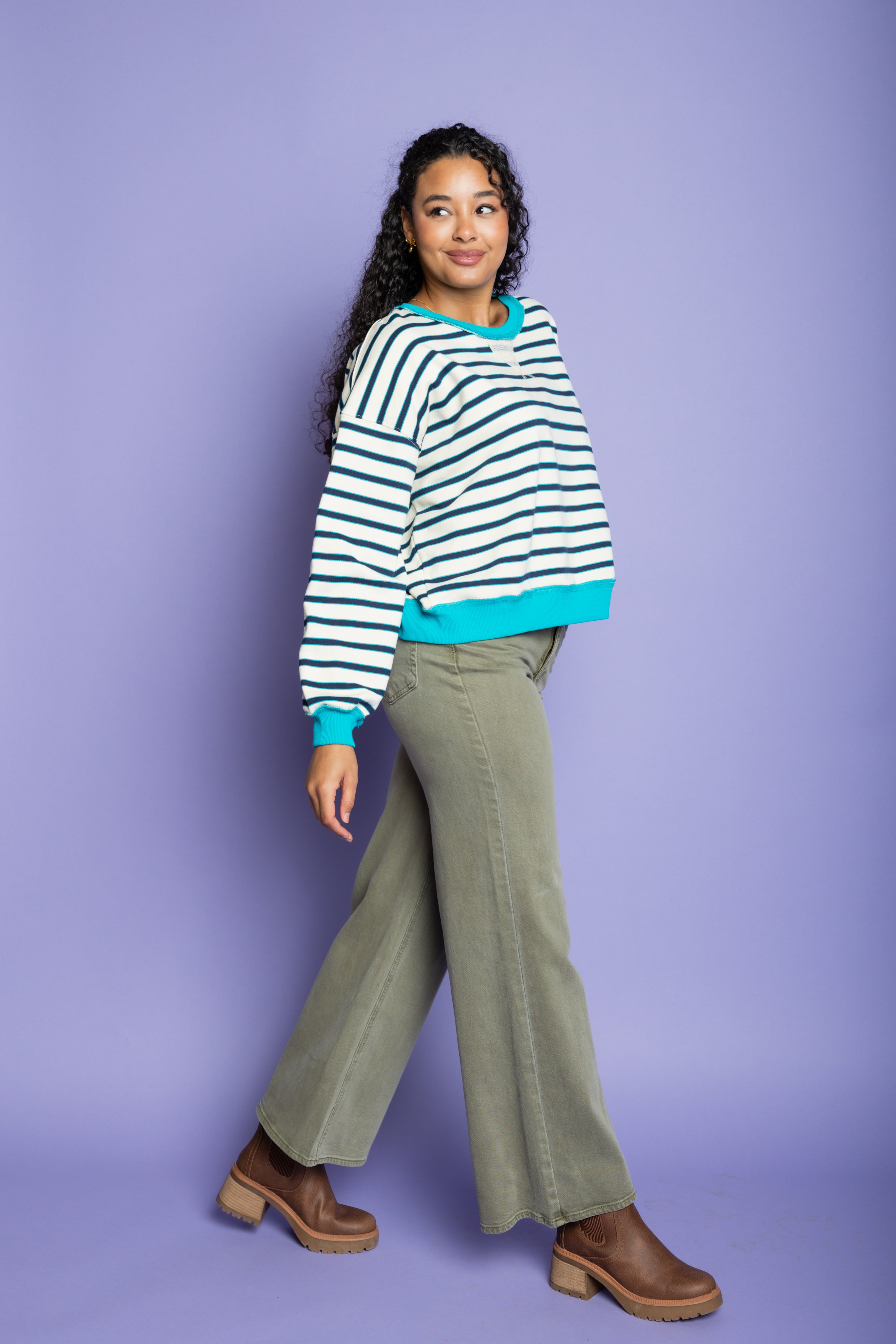 Model is wearing green wide leg pants with striped blue and white top