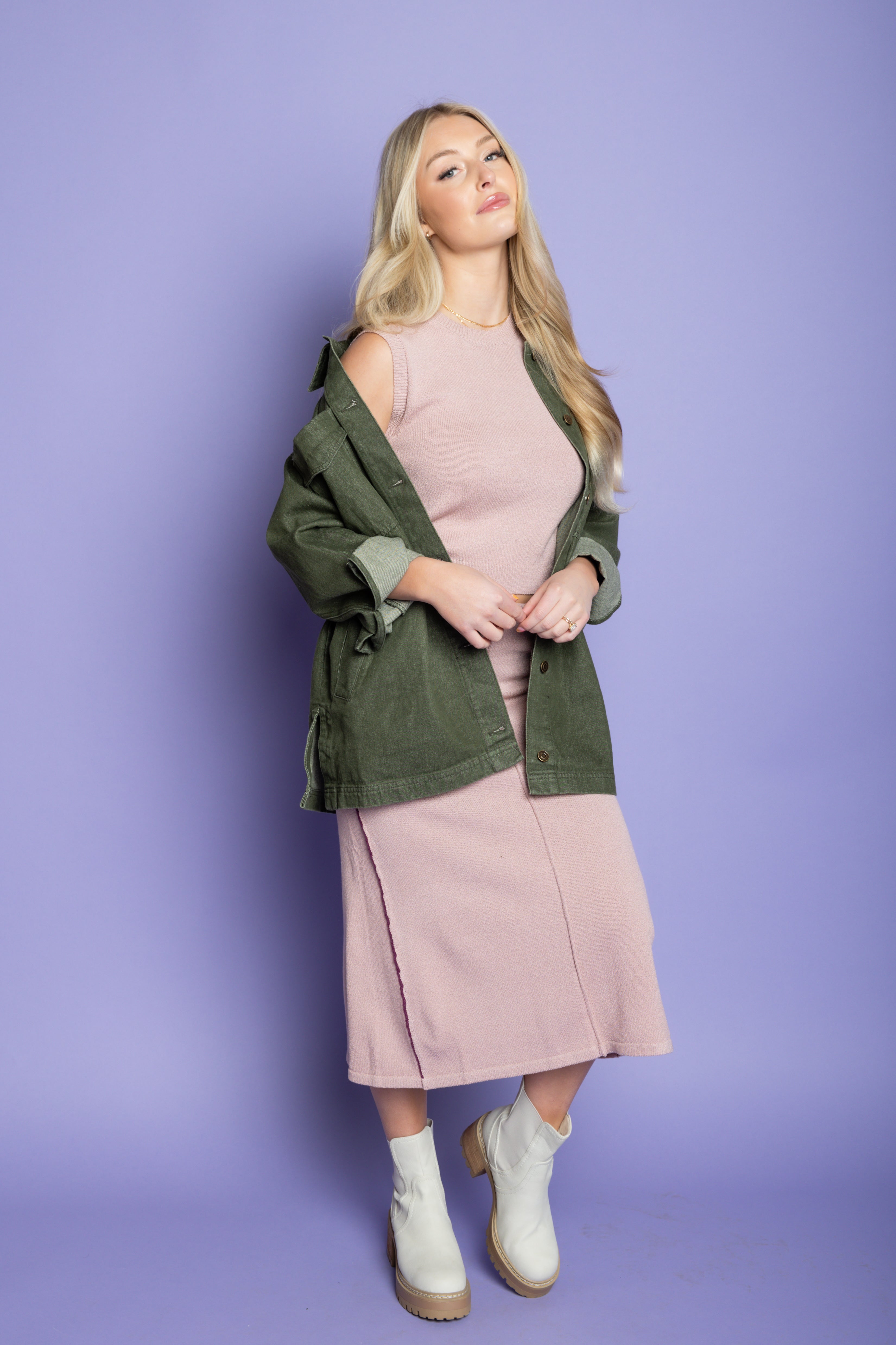 Model is wearing green utility jacket with pink matching skirt set. 