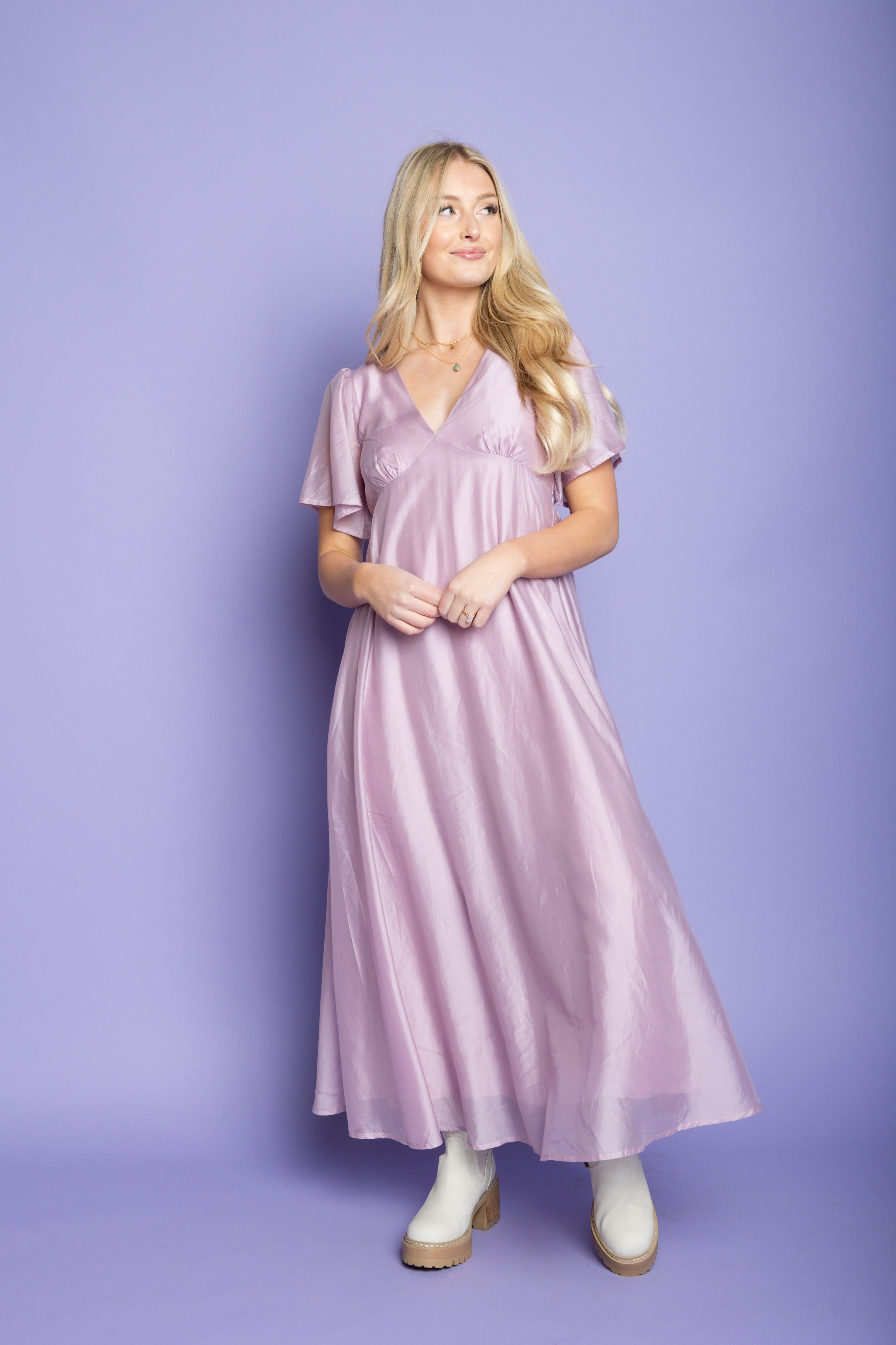 Model in a photoshoot wearing a purple silk midi dress