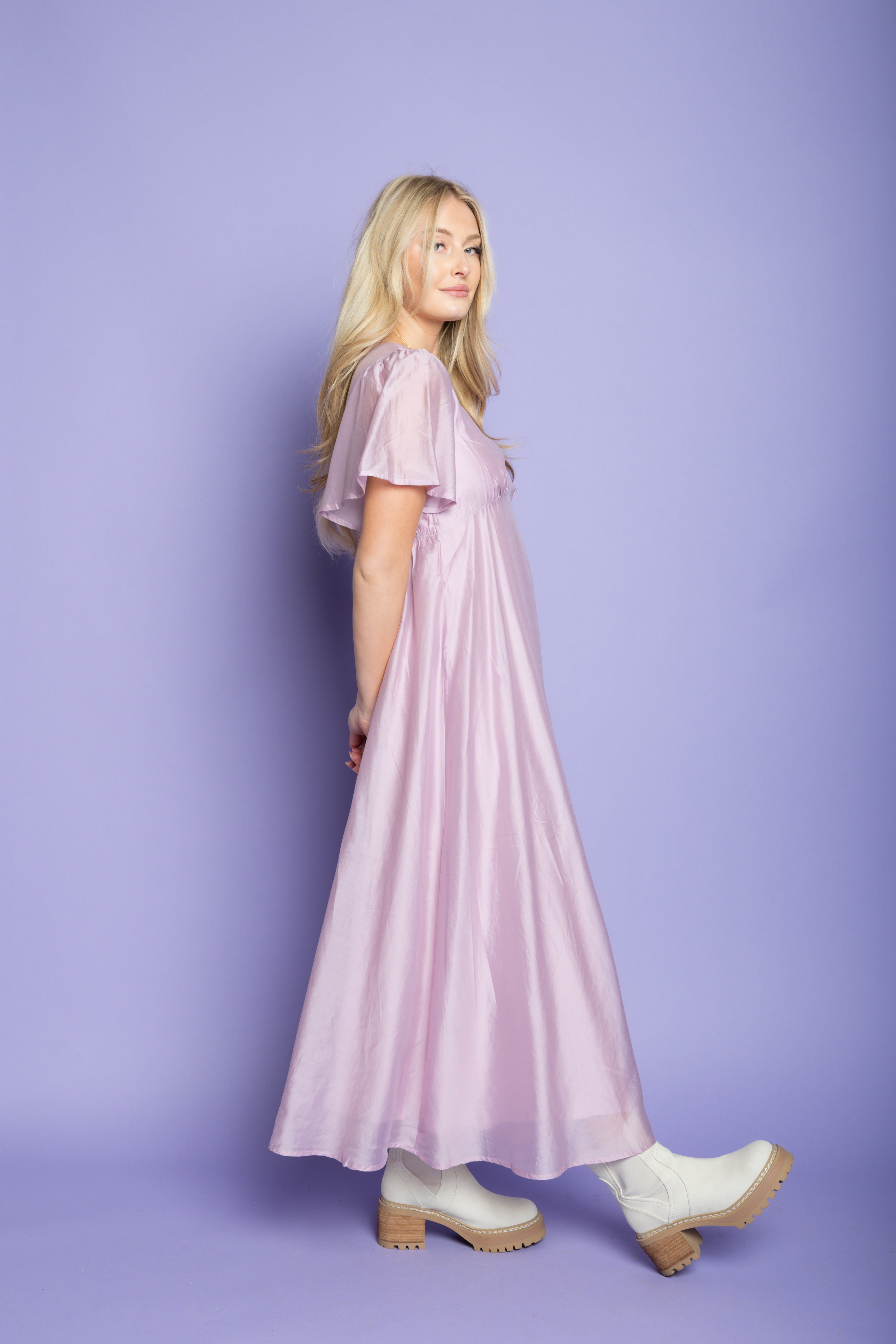 Model in a photoshoot wearing a purple silk midi dress