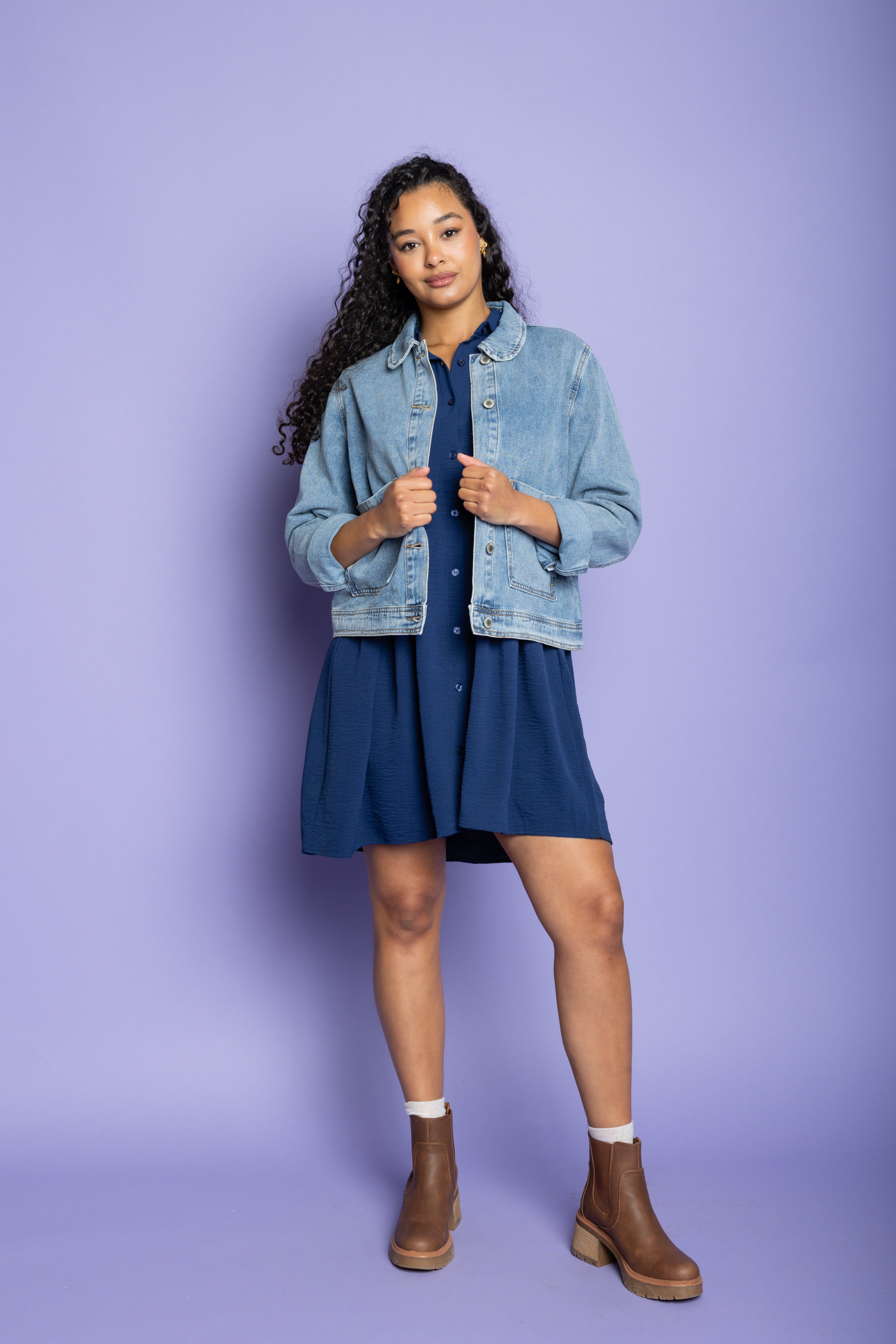 Model wearing denim jacket and blue mini dress. 