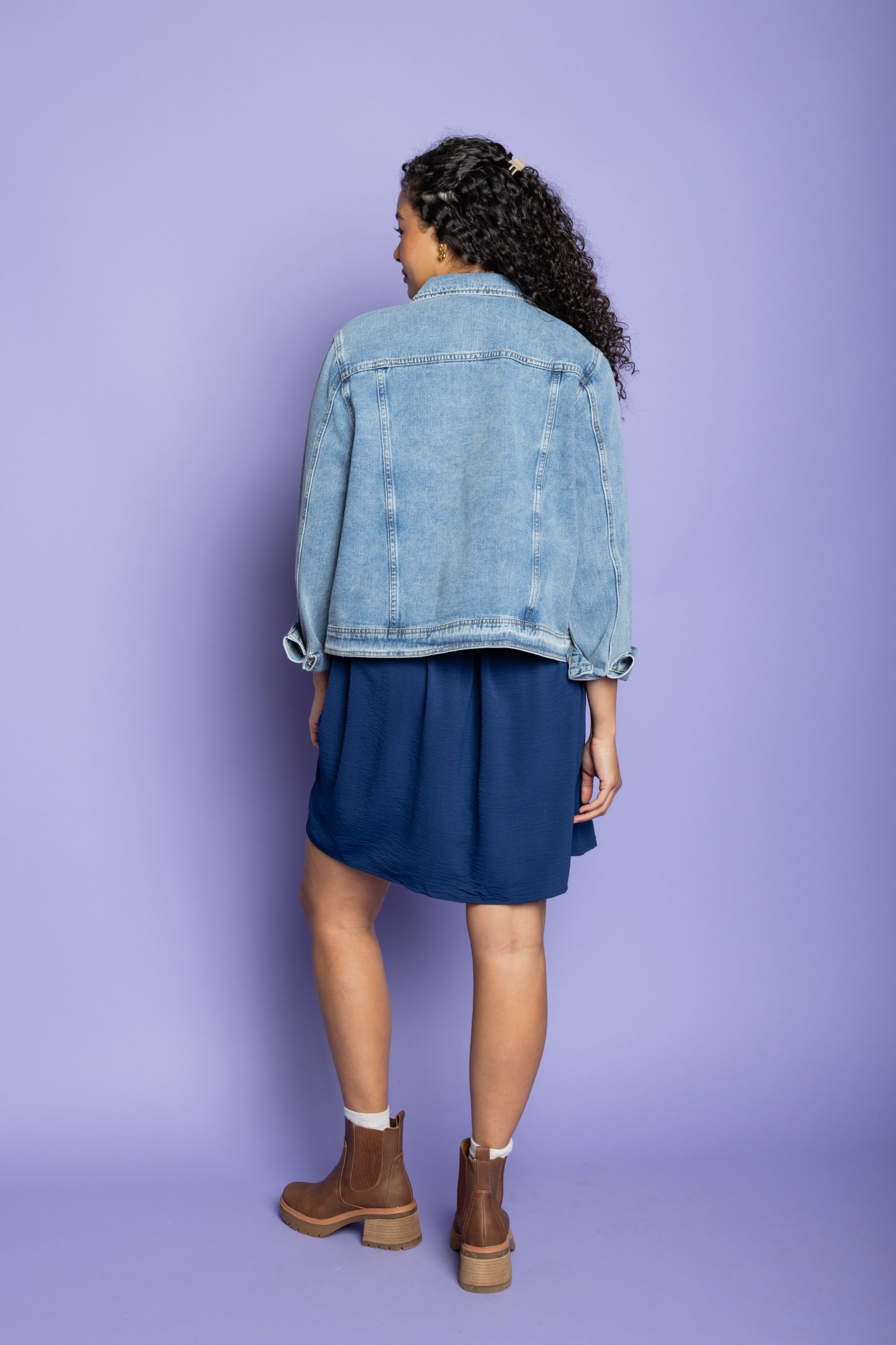 Model wearing denim jacket and blue mini dress. 