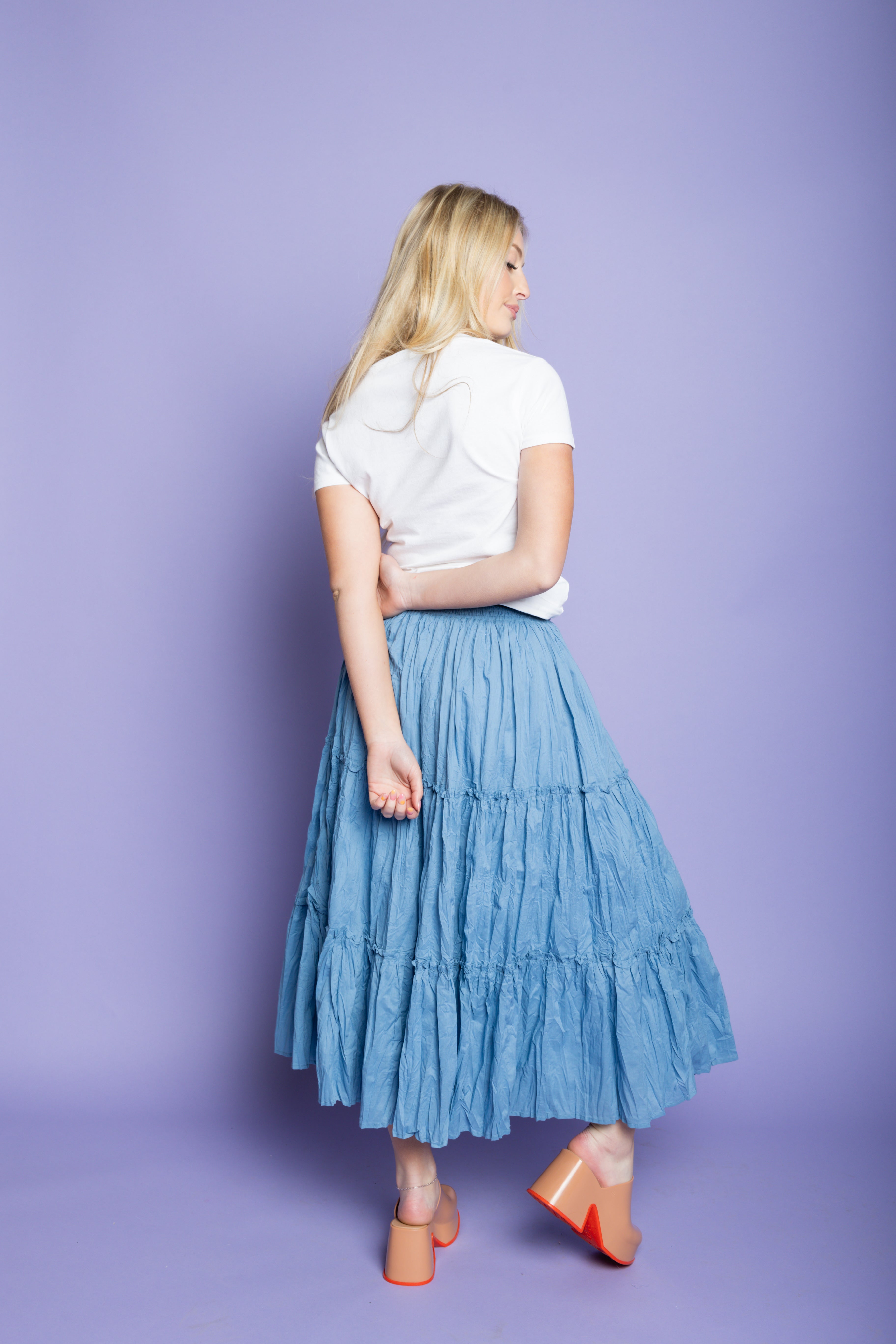 Model is wearing Italian t-shirt with ruffled maxi skirt.