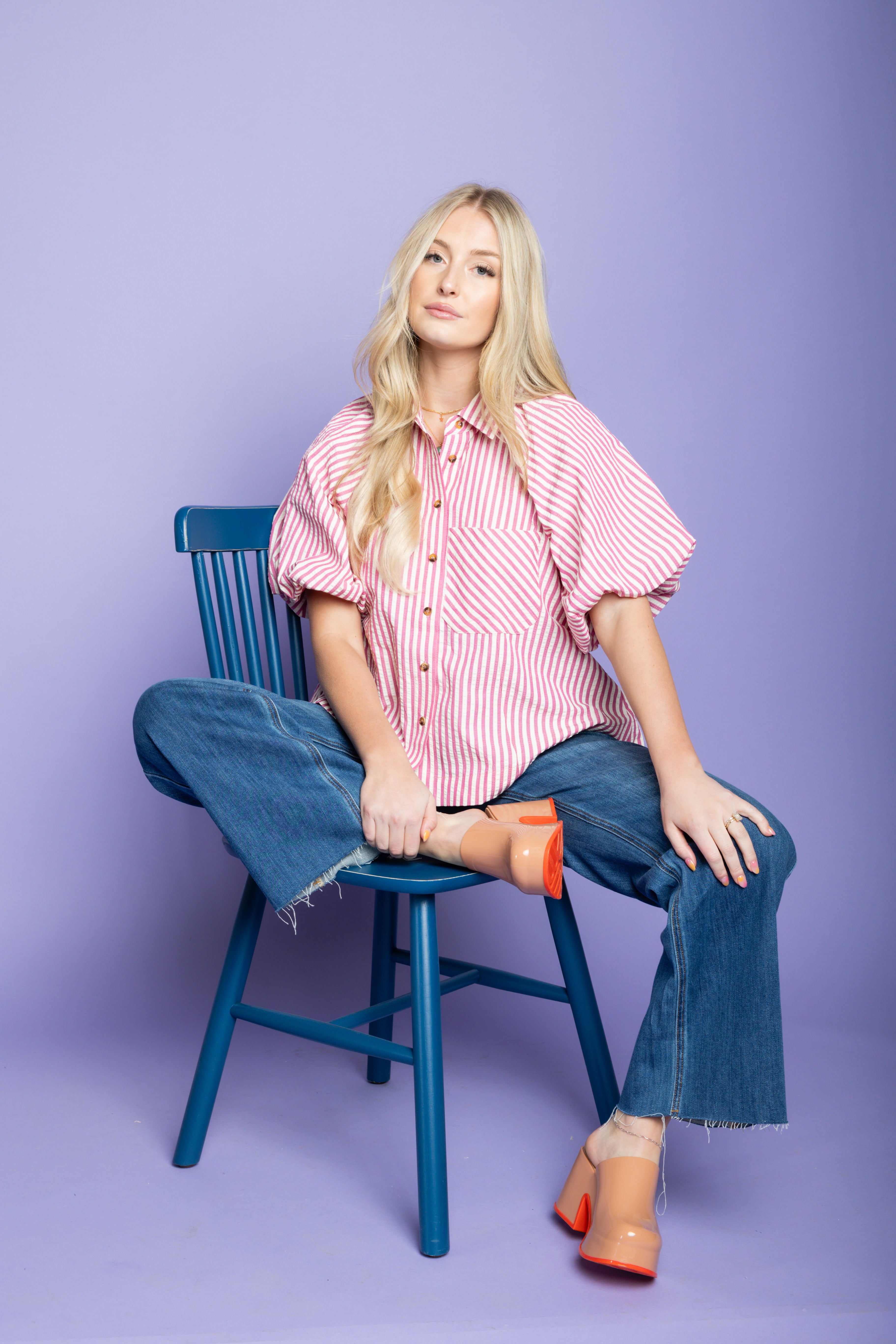 Model is wearing a striped puffer blouses with jeans.