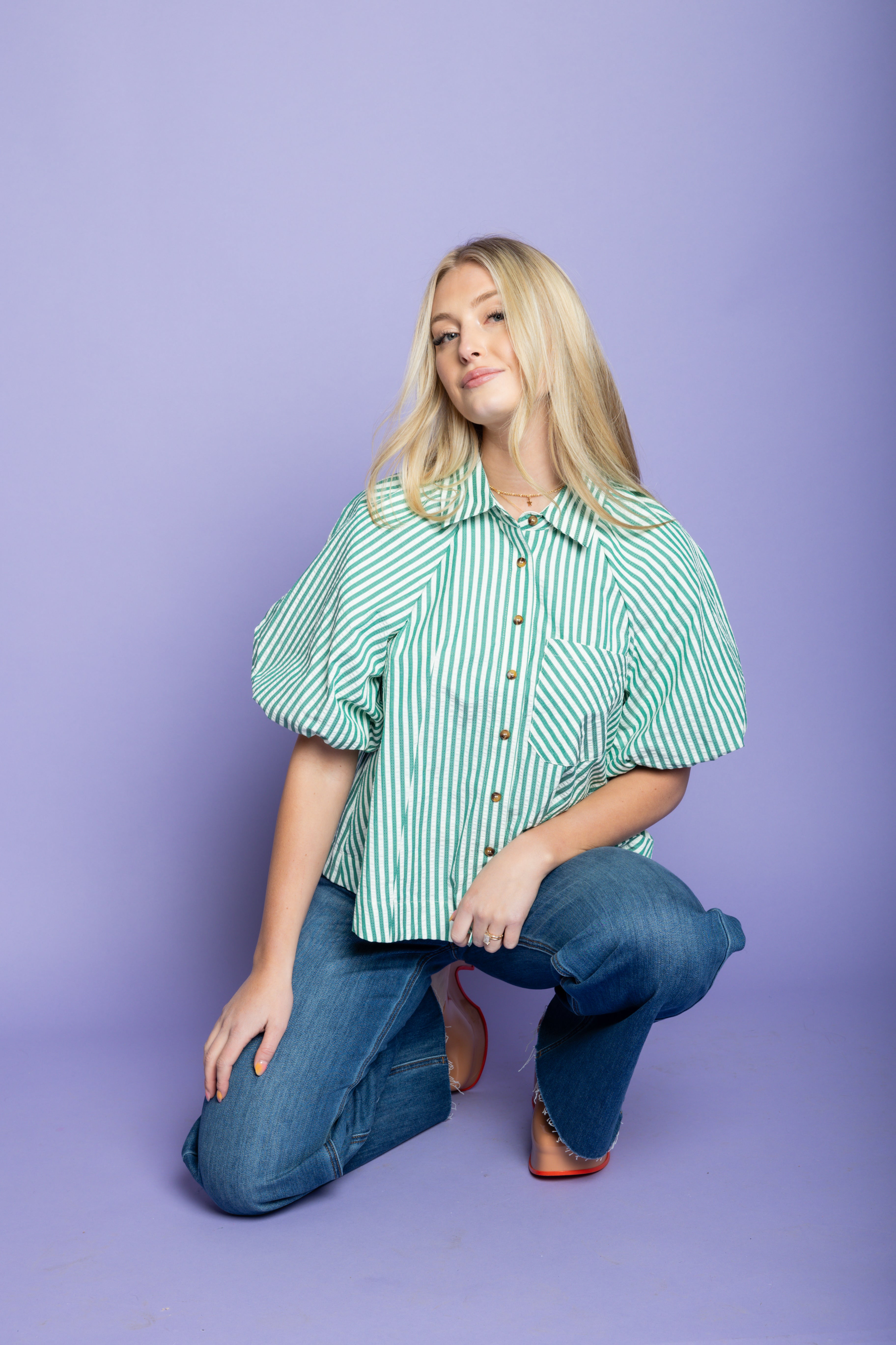 Model is wearing a striped puffer blouses with jeans.