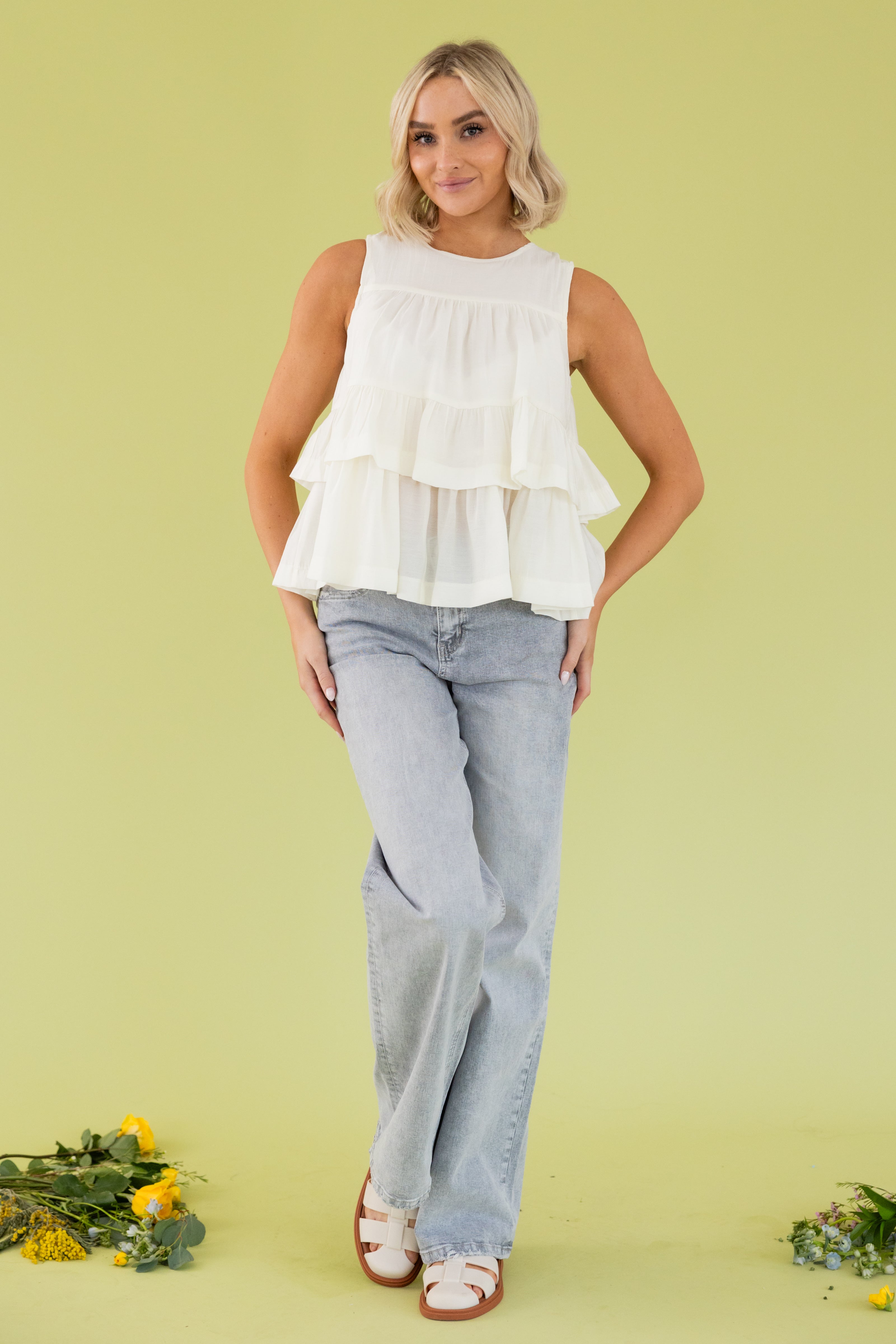 Model is wearing a ruffle halter tank top with grey jeans. 